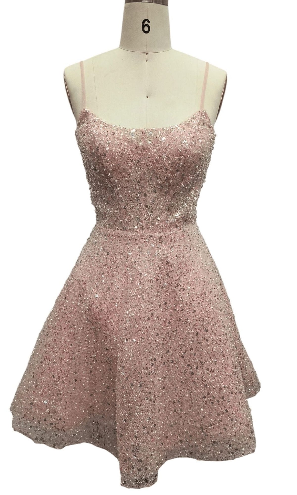 The Short Pink Sequin Hoco Dress: 12461 is a sleeveless, knee-length designer party dress in light pink with thin straps and sparkling sequin embellishments, displayed on a dress form.