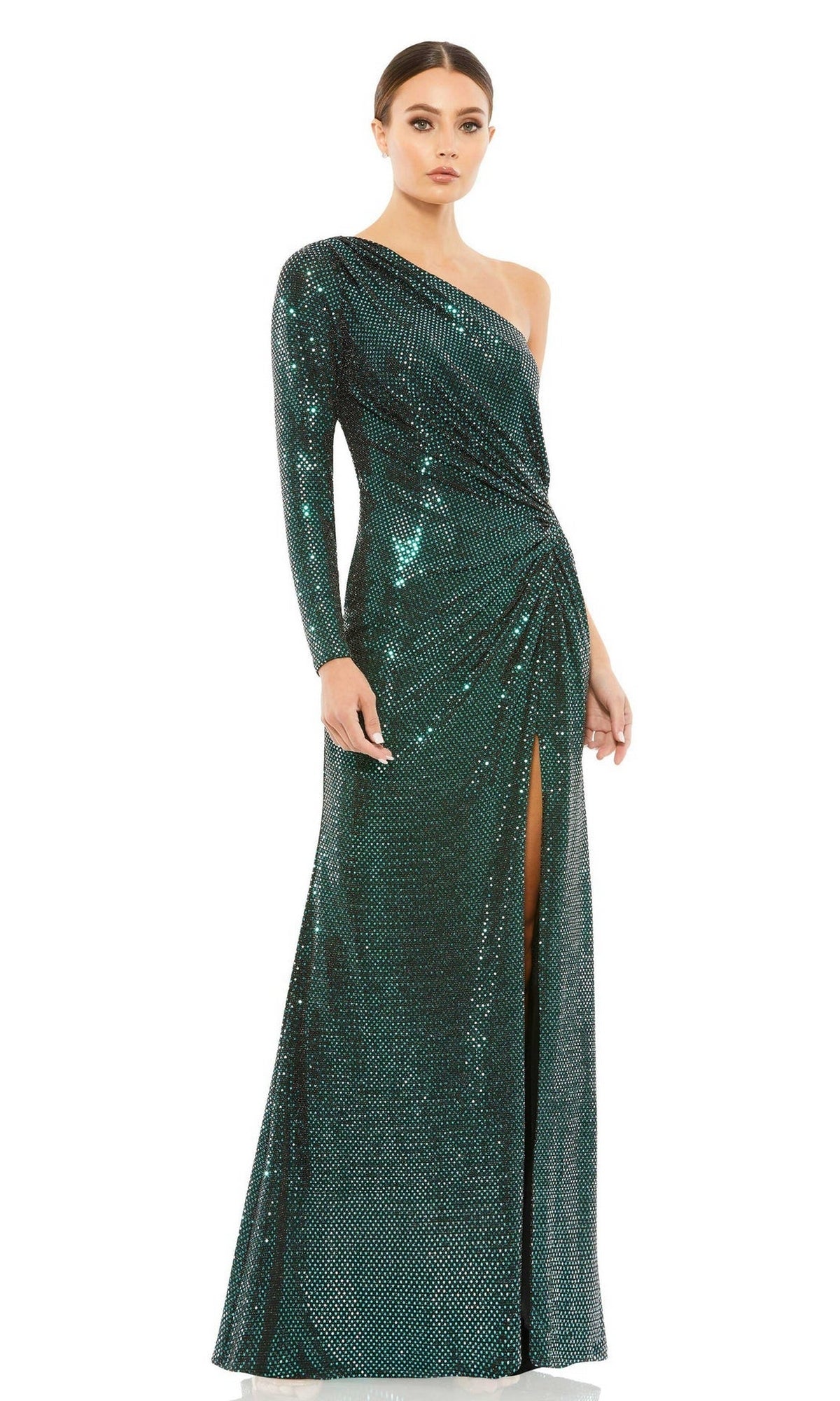 A woman wears the Mac Duggal 12501 long green sequin formal dress, featuring a one-shoulder design, fitted silhouette, and thigh-high slit.