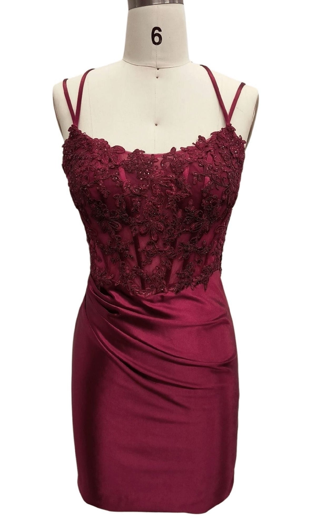 The Short Burgundy Hoco Dress: Dave & Johnny 12619 is a sleeveless, semi-formal dress with lace floral bodice embroidery and a draped satin skirt, shown on a dress form labeled 6.