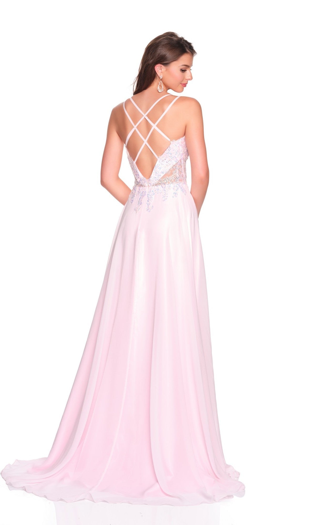 A woman models the Dave and Johnny 12630 long prom dress—a light pink chiffon A-line gown with a flowy silhouette, crisscross straps, and an open strappy back—standing against a plain white background.