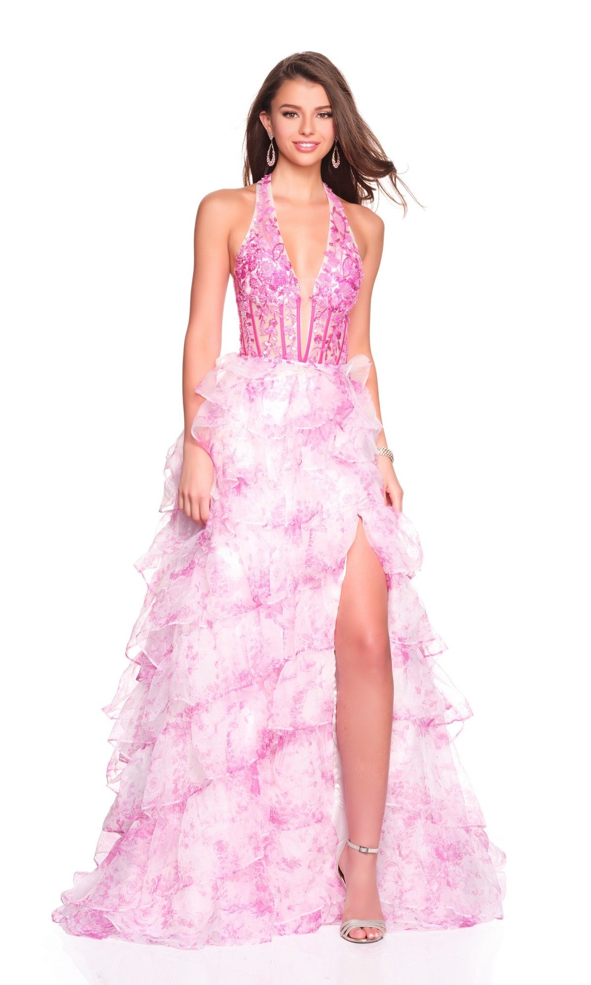 A woman models the Dave and Johnny 12766 long prom dress—a halter pink gown with an embellished fitted bodice, ruffled chiffon A-line skirt, and high slit—paired with silver heels against a white background.