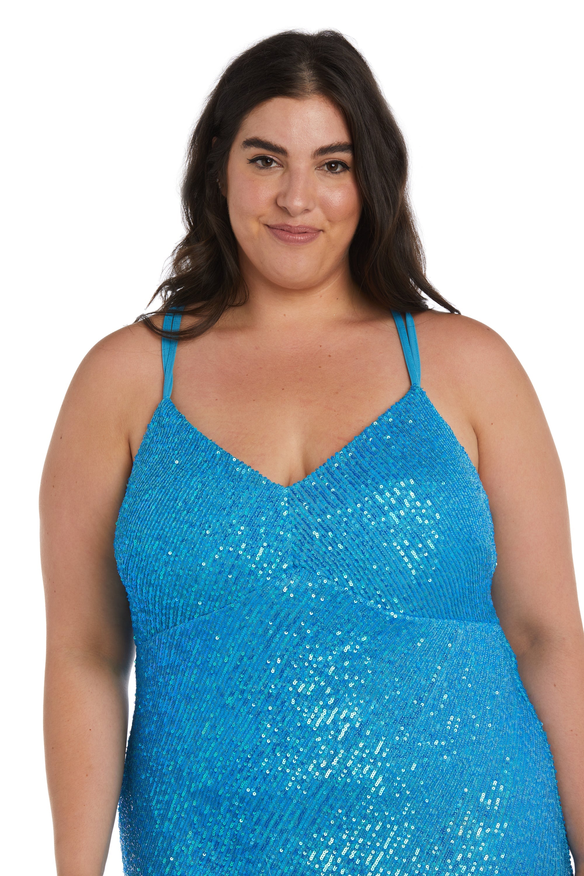A woman with long dark hair wears the Long Plus-Size Sequin Prom Dress: Morgan 13029WM, featuring a blue color, thin straps, and v-neckline. She smiles slightly at the camera against a white background.