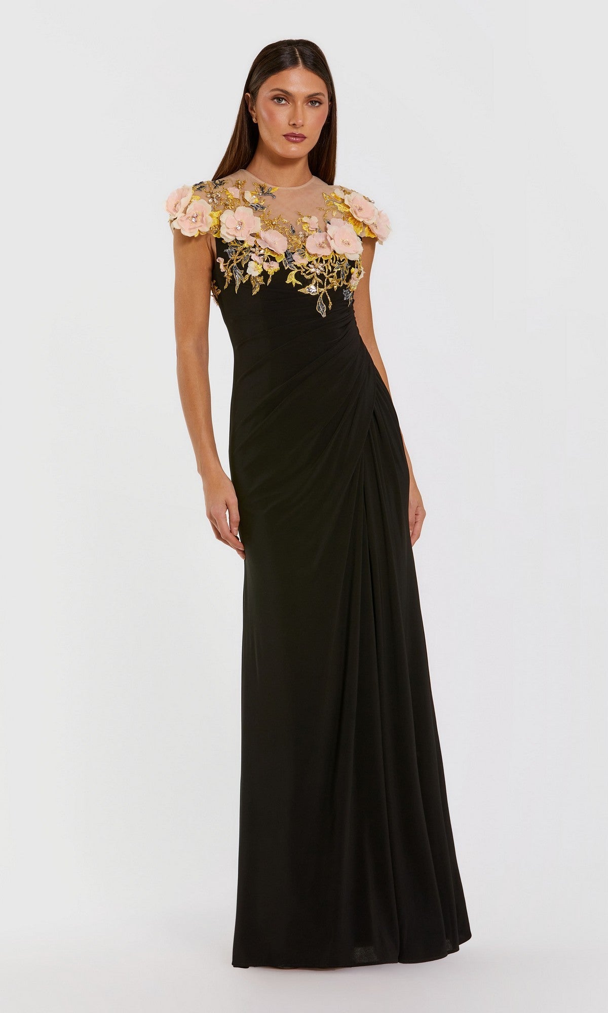 A woman stands against a plain white background, wearing the Mac Duggal 13207 long formal dress in Black Multiโa gorgeous jersey gown featuring 3D floral accents on the sheer neckline and cap sleeves.