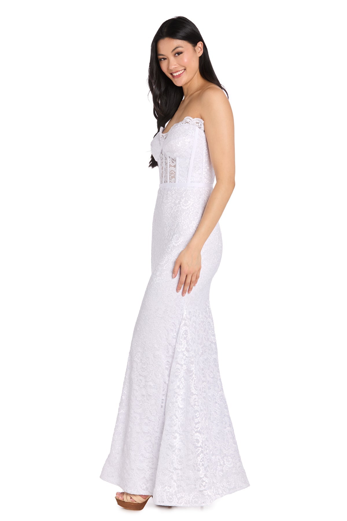 A woman models the Morgan 13269 Strapless Long Lace Prom Dress, a fitted, floor-length white gown with a mermaid silhouette, standing in profile against a white background.
