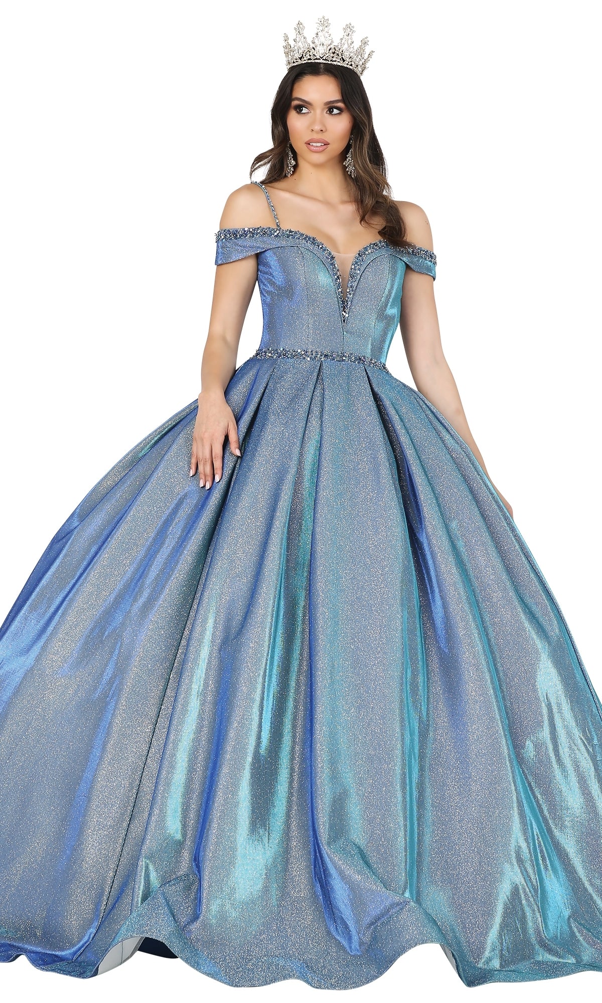 A woman wears the Quinceanera Dress 1506 by Dancing Queen—an off-the-shoulder, silver-blue A-line gown with a sweetheart neckline and a tiara—standing against a white background.
