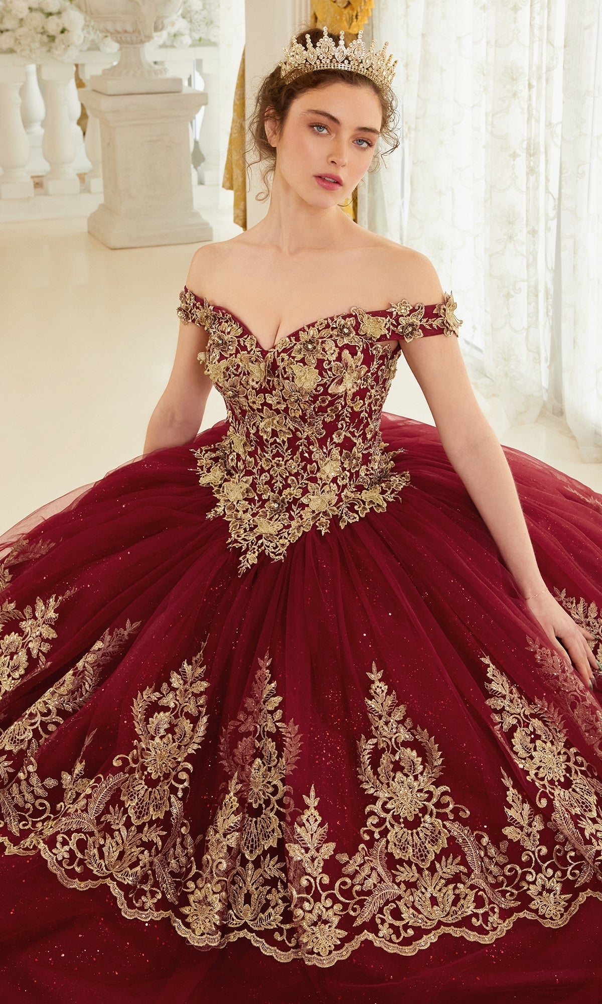 A woman wearing the Ladivine 15705 Quince Dress with gold embroidery and a gold tiara stands indoors against a light background.