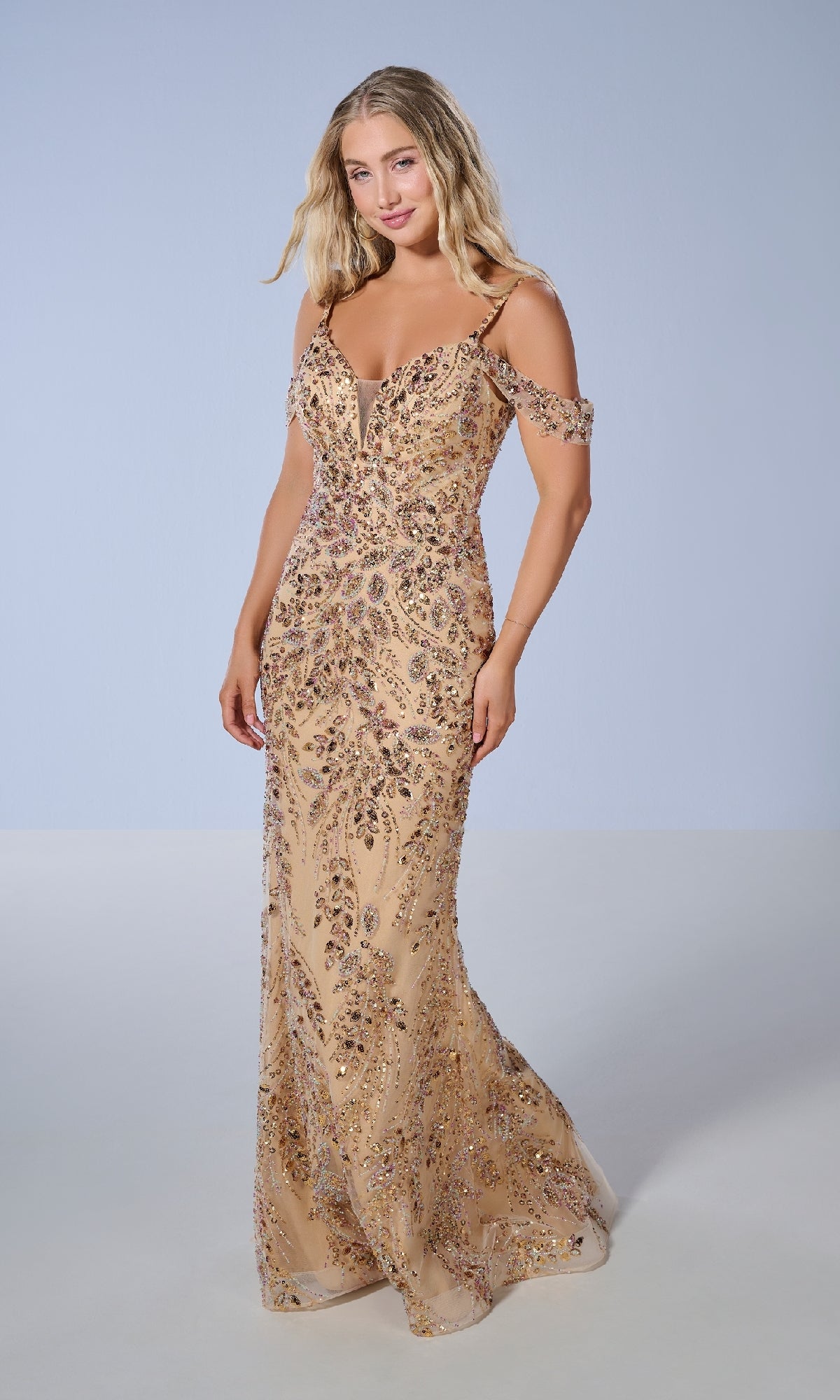 A woman models the Tiffany 16230 long prom dress, featuring a fitted beaded design with intricate floral patterns and off-the-shoulder style, set against a plain beige backdrop.