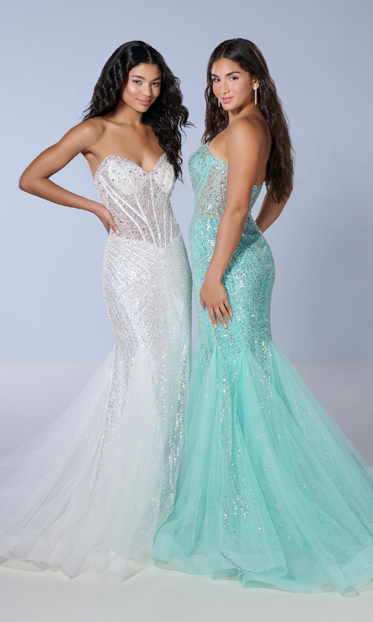 Two women wear the Long Prom Dress: Tiffany 16232—one in white, one in light blue—both featuring a strapless mermaid design with a fitted silhouette and elegant sweetheart neckline, standing side by side against a plain background.