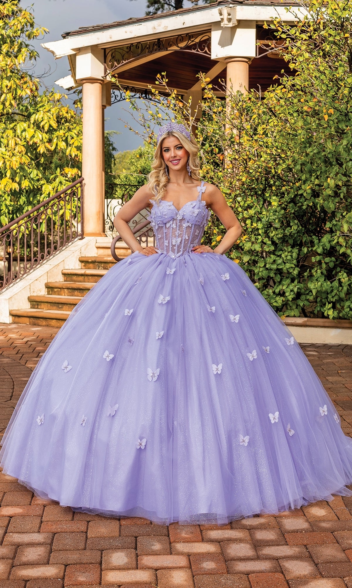 A woman in a luxurious purple quinceañera a-line ball gown with sweetheart neckline and bow detail on the back, standing outside.