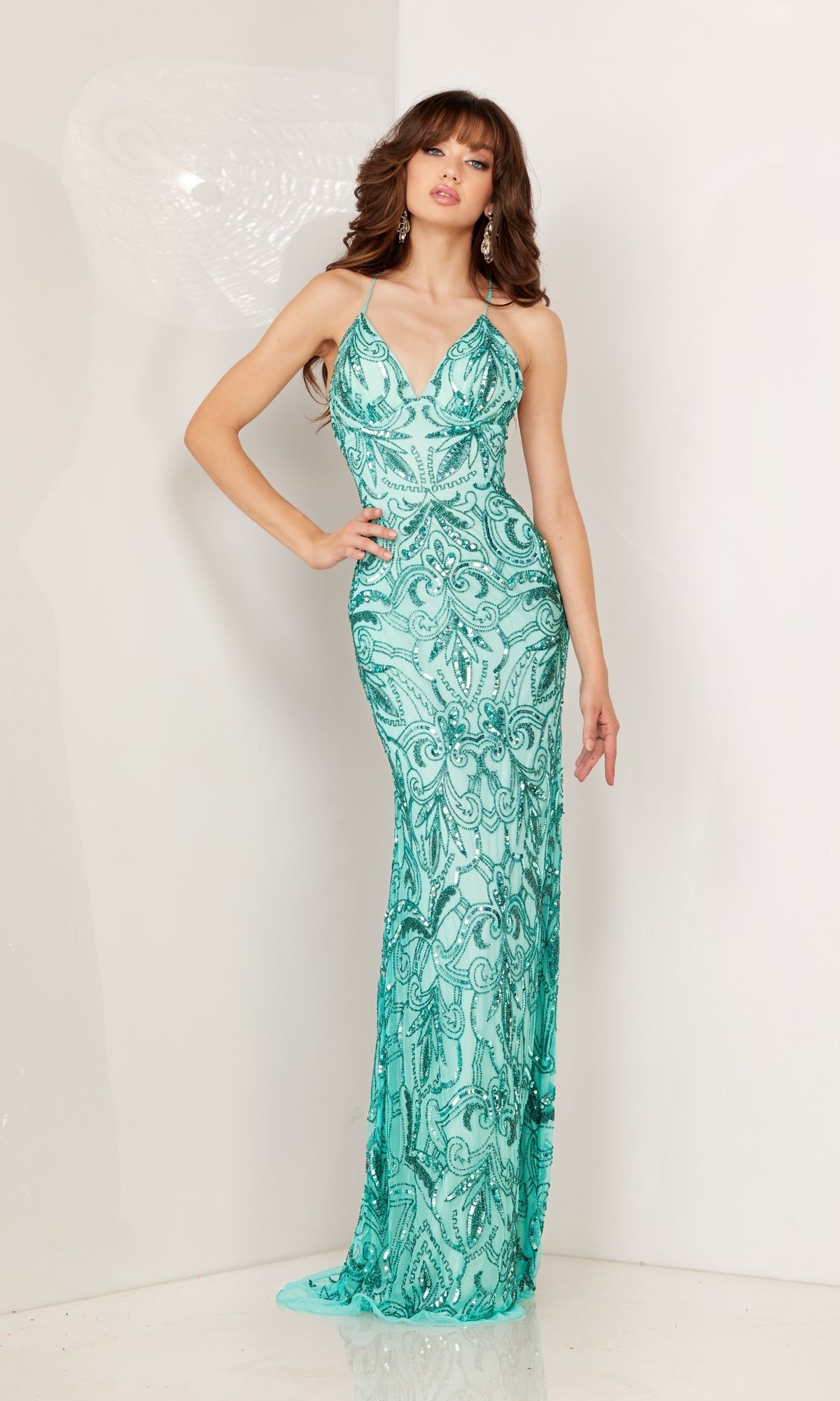 A woman poses against a white background in the Long Sequin-Print Prom Dress with a fitted, floor-length silhouette, strappy open back, spaghetti straps, and shimmering sequins.