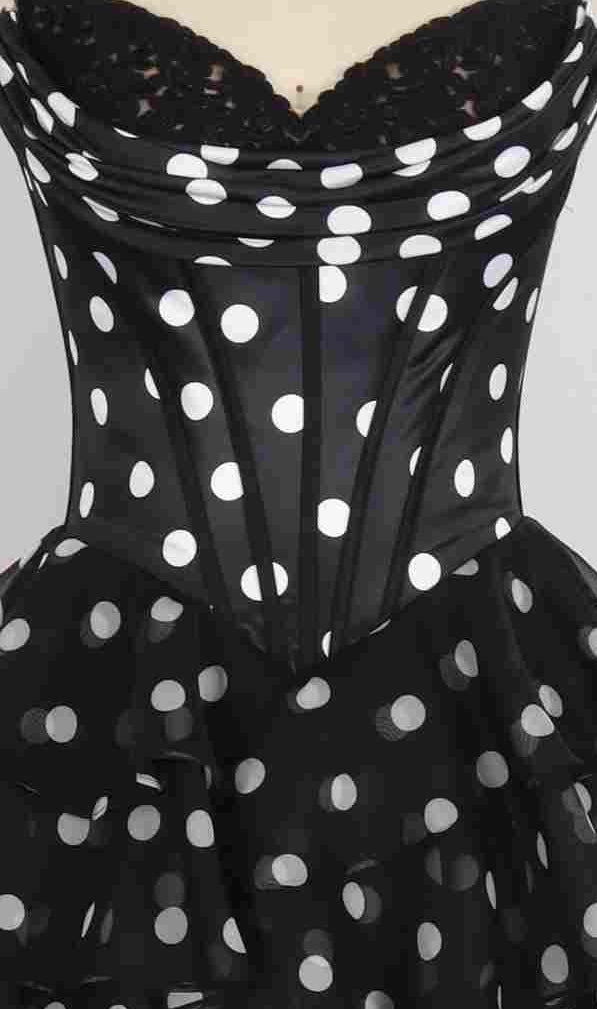 Close-up of the PromGirl Exclusive 250123B long prom dress, featuring a satin corset bodice and ruffled skirt in black fabric with white polka dots.