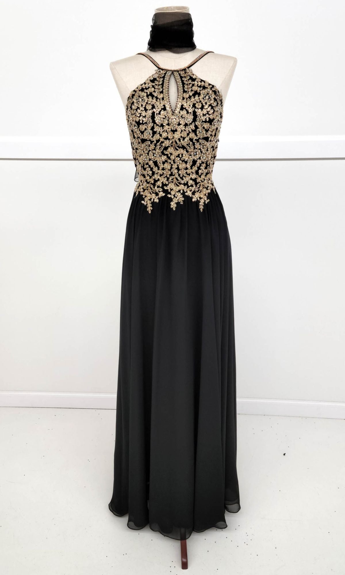 Chicas C1521: High-neck, floor-length A-line prom dress featuring a golden lace embroidered bodice, keyhole neckline, and flowing chiffon skirt displayed on a dress form against a plain background.