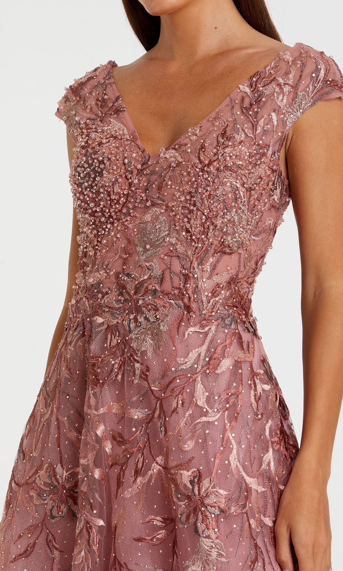 Woman wearing the Cap-Sleeve Long Print Prom Dress (Mac Duggal 20263) with intricate beading and embroidered floral prints, shown from mid-torso to just above the knees.