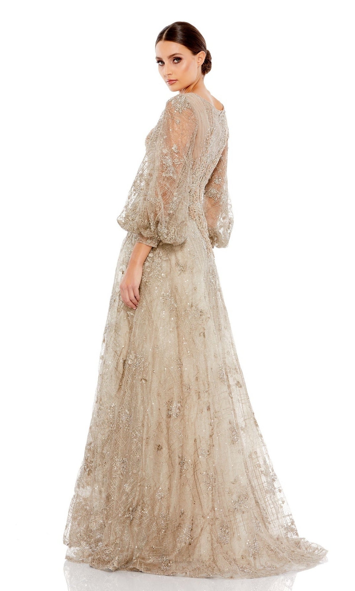 A woman stands against a white background, looking over her shoulder in the Long Formal Dress 20283 by Mac Duggal, featuring embroidered sheer puff sleeves and intricate detailing.