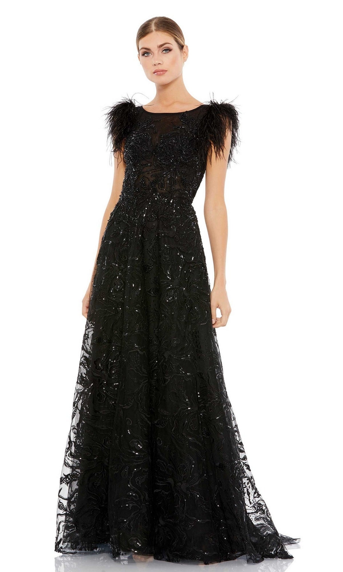 A woman wears the Mac Duggal 20296 Feather Long Black Formal Dress, a floor-length gown with sheer details, beaded embellishments, feathered shoulder accents, and embroidered lace for an elegant look.