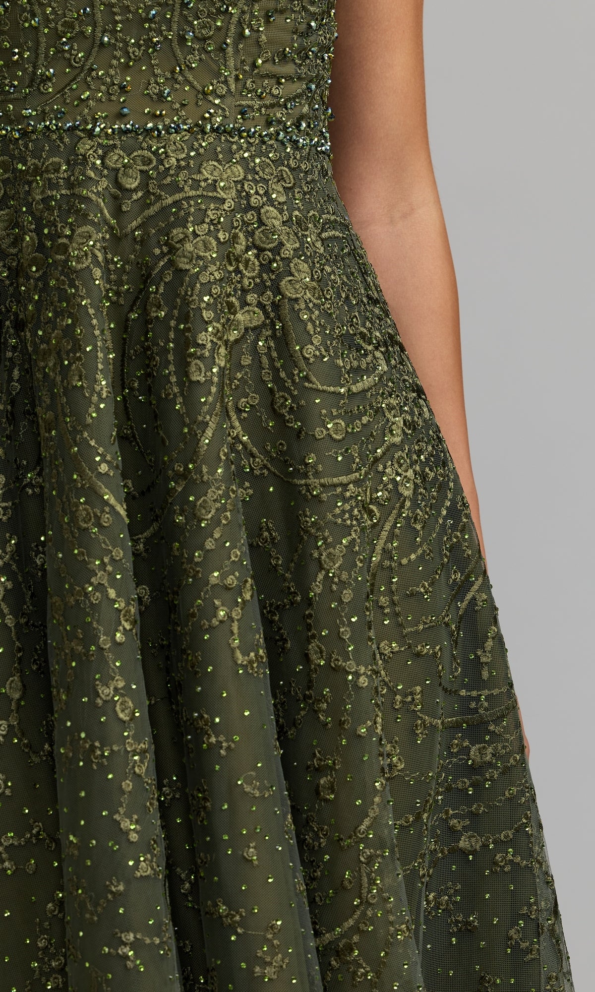 Close-up of a person wearing the Tea Length Lilac Party Dress by Mac Duggal (style 20338), featuring cap sleeves and intricate beaded detailing, set against a plain gray background.