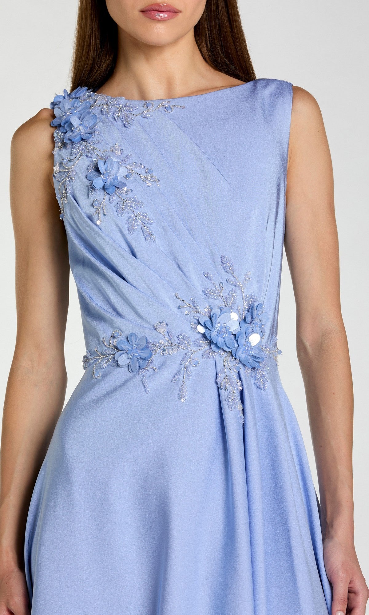 A woman wears the Mac Duggal 20365, a sleeveless long formal dress featuring floral appliqué and bead embellishments on the shoulder and waist.