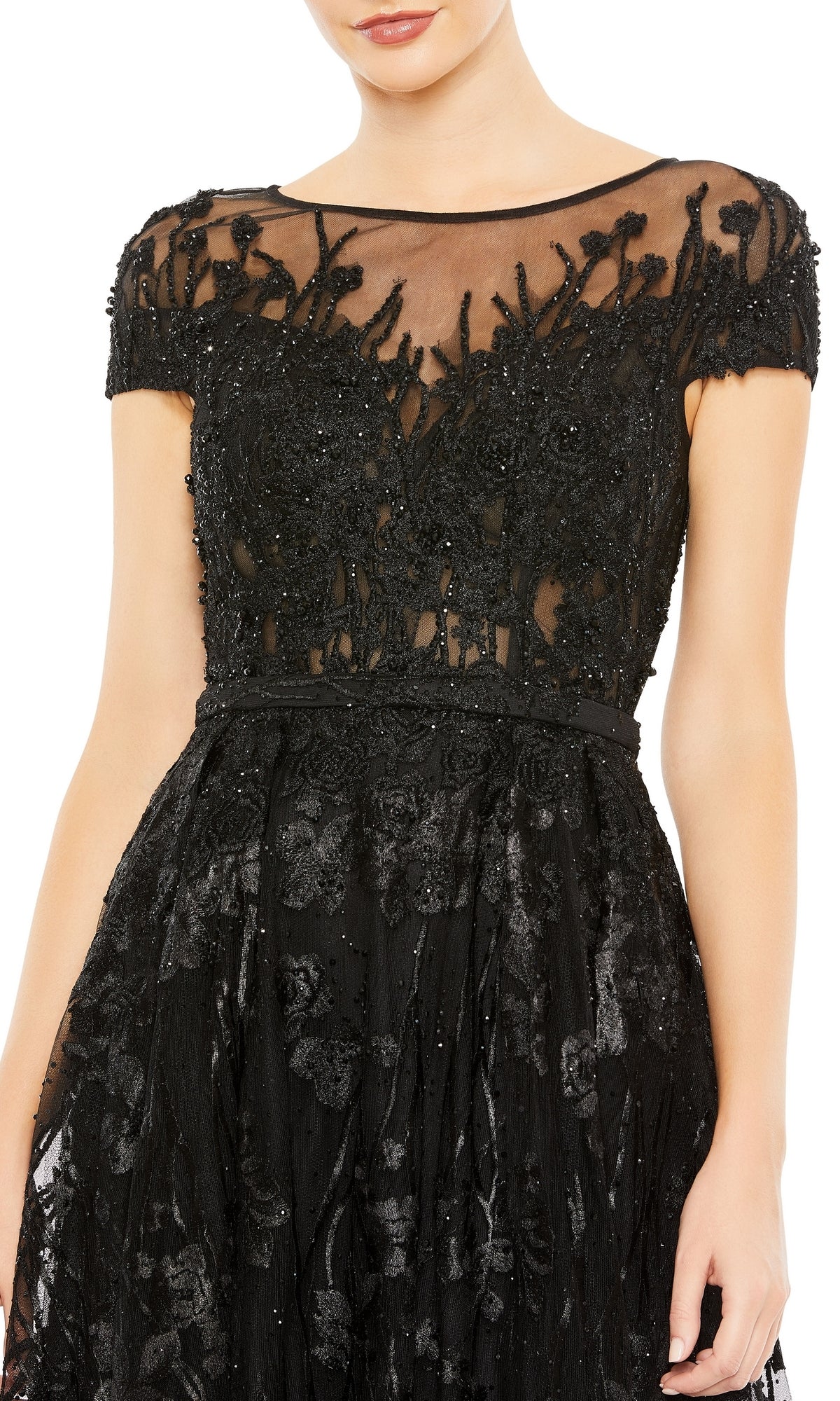 A woman in the Mac Duggal 20405 Short-Sleeve Long Formal Dress, featuring black floral lace and beaded embellishments on a sheer bodice.