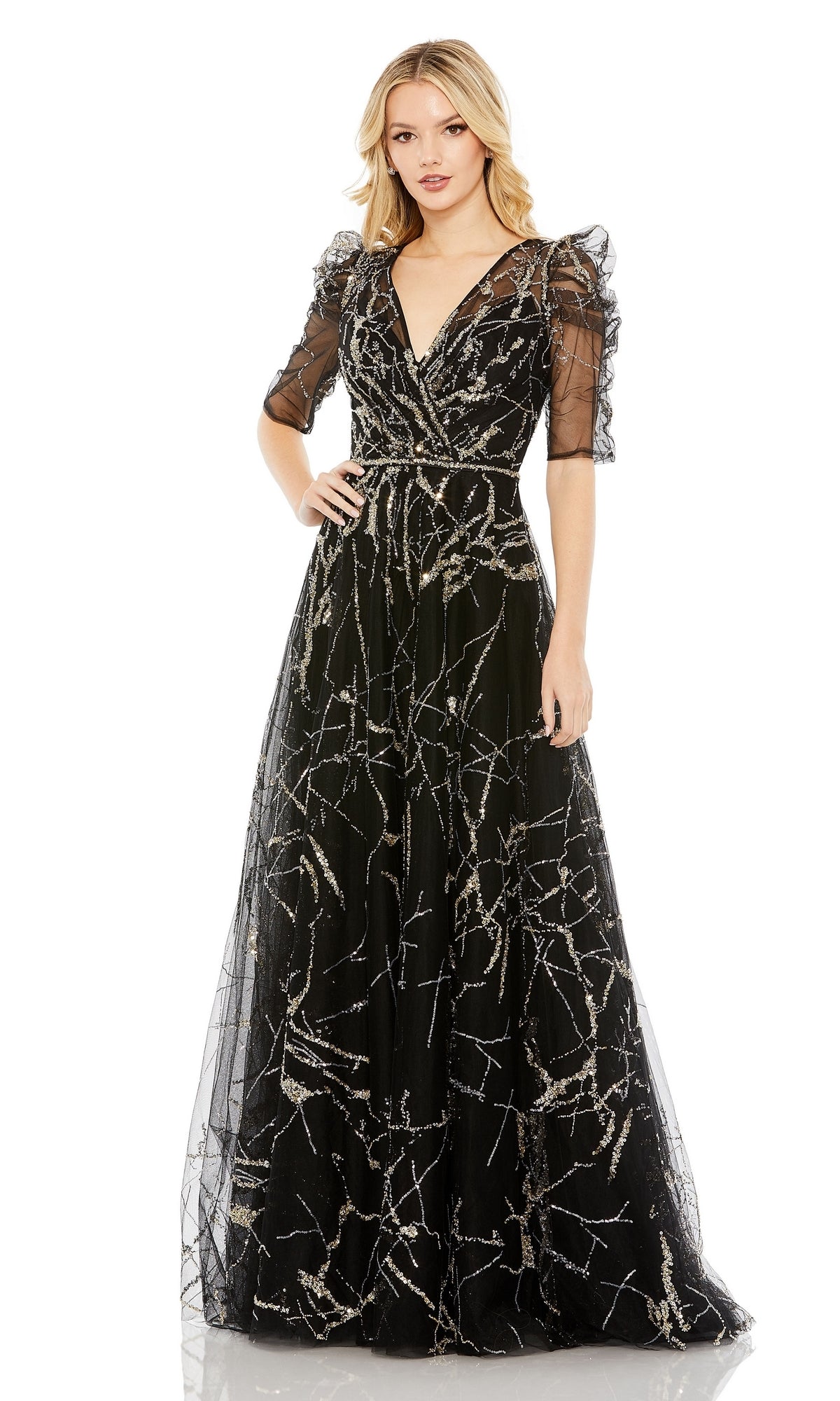 A woman wearing the Long Formal Dress 20428 by Mac Duggal—a black A-line gown with silver sequin patterns, sheer puff sleeves, and a v-neckline—stands facing forward.