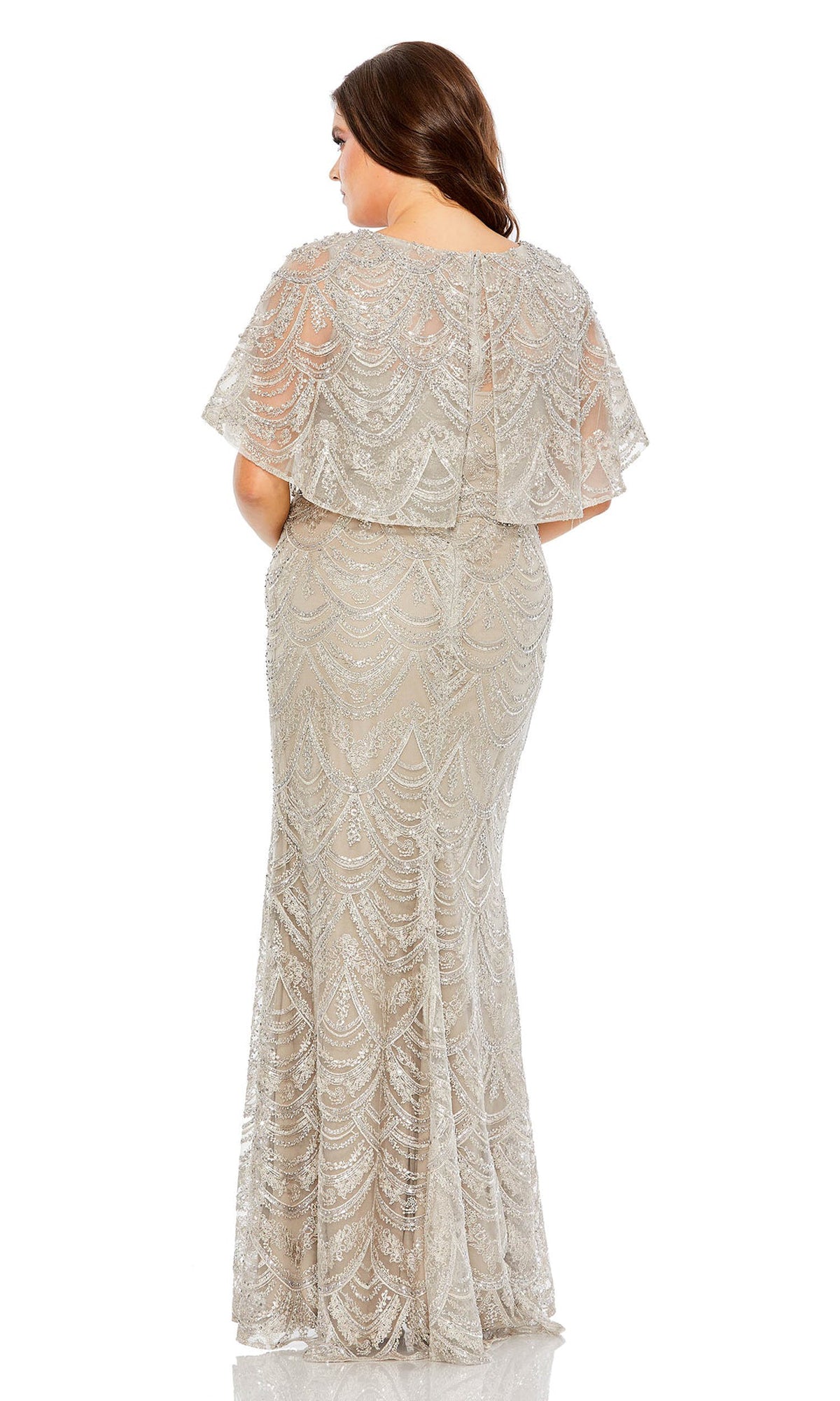 A woman models the Long Plus-Size Formal Dress 20470 by Mac Duggal, featuring silver beading and a short sleeve cape bodice, shown from the back against a white background.