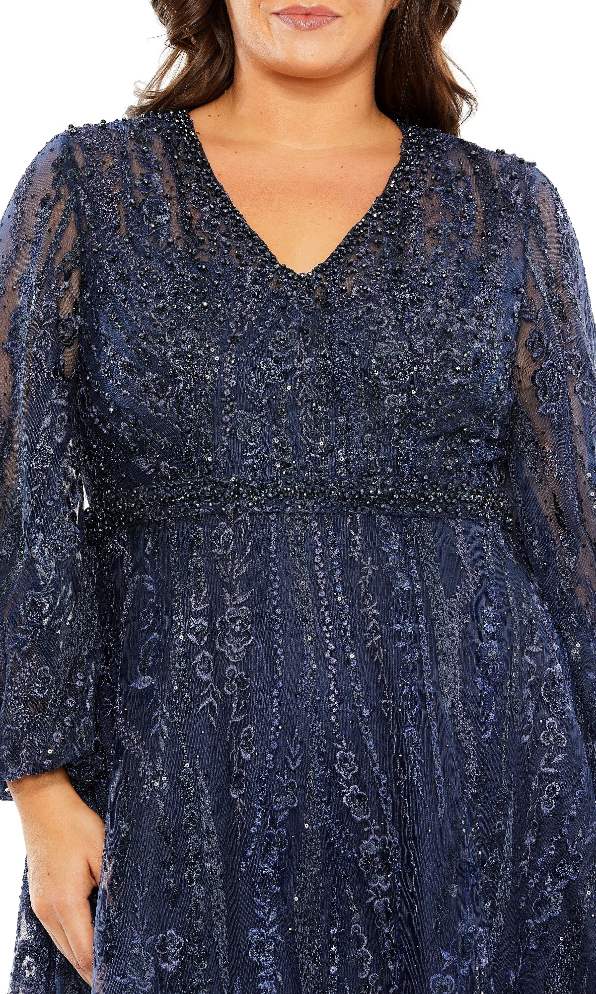 A woman wearing the Mac Duggal 20472 long plus-size formal dress in navy blue, featuring beaded lace, elegant long sleeves, a V-neckline, and intricate floral embroidery; shown from shoulders to mid-thigh.