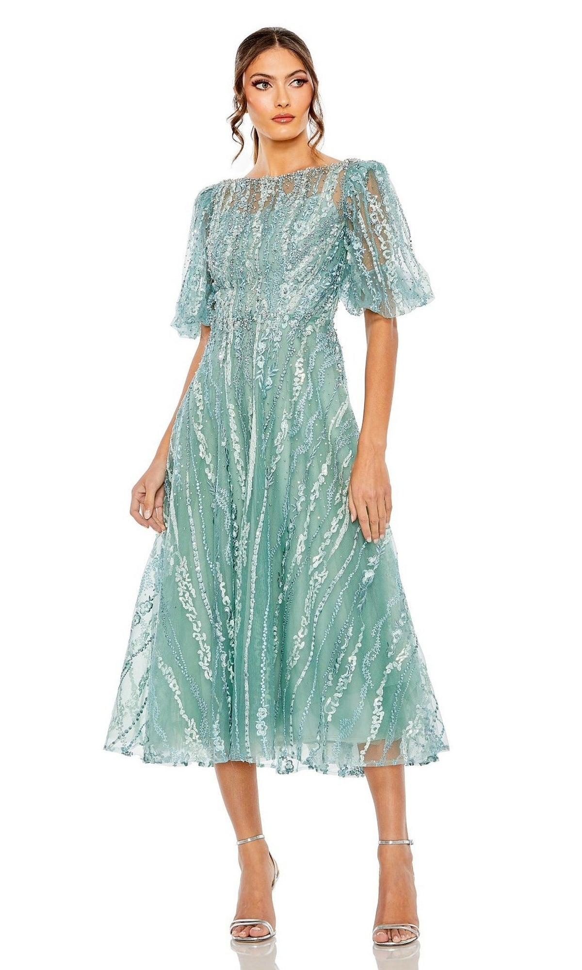 Woman in Mac Duggal 20485, an embroidered wedding-guest dress with light teal lace, short flutter sleeves, fitted waist, and strappy silver heels—an elegant choice for special occasions.