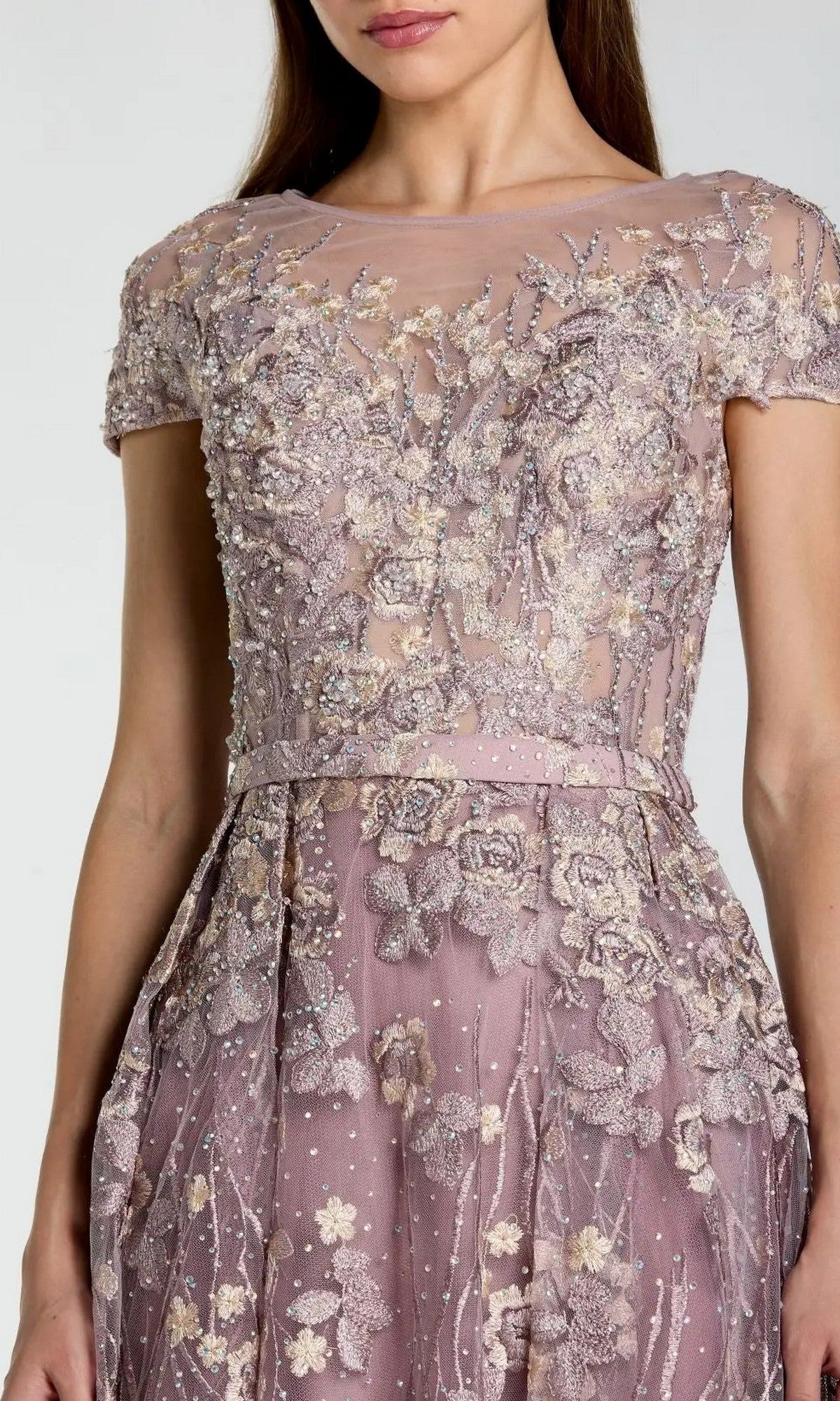 A woman wearing the Tea-Length Party Dress: Mac Duggal 20502—a short-sleeved, mauve evening gown featuring intricate floral embroidery, a sheer neckline, and beaded details—an exquisite floral applique dress perfect for any elegant occasion.