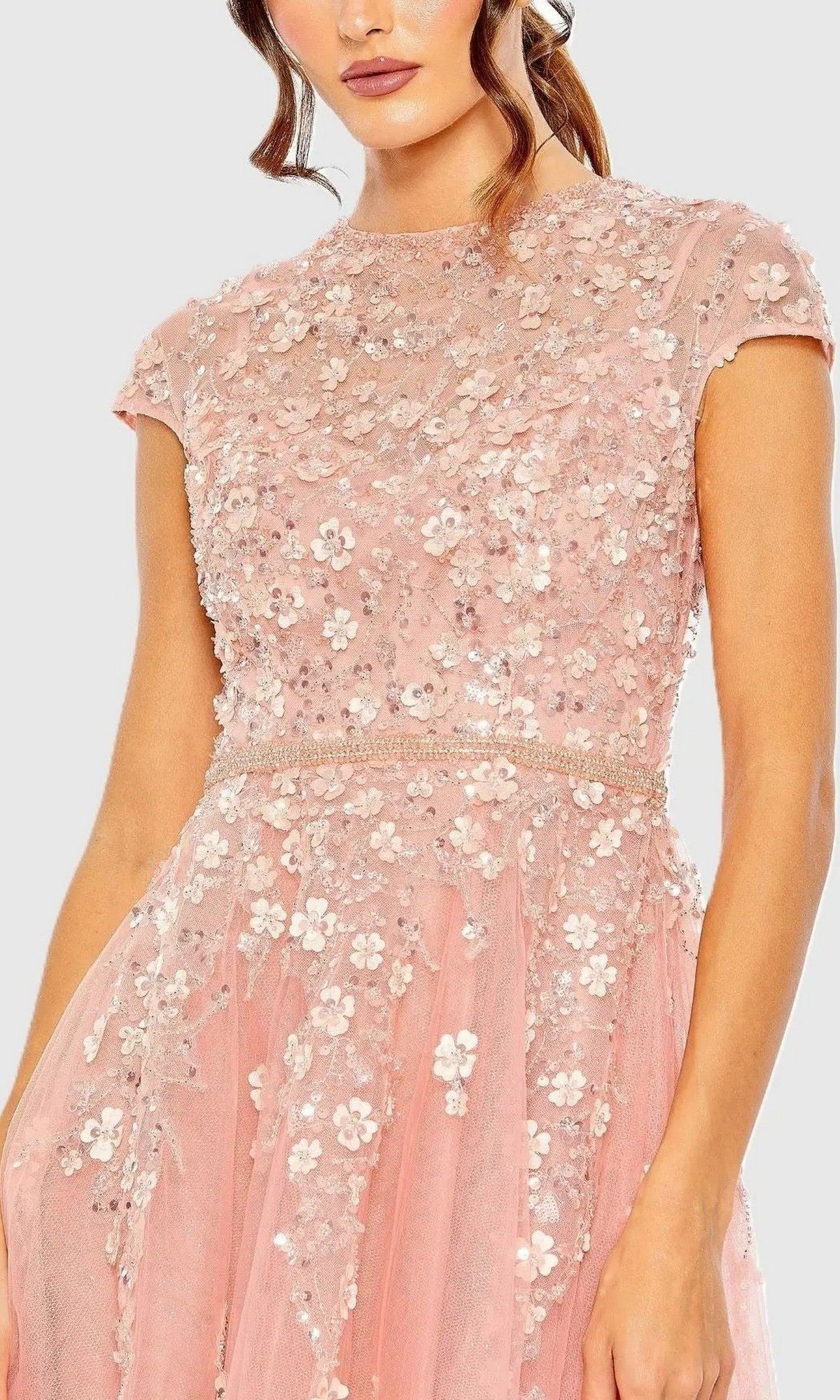 A woman is shown from shoulders to mid-thigh wearing the Mac Duggal 20511 long formal dress in pink, featuring floral embroidery and sequin embellishments.