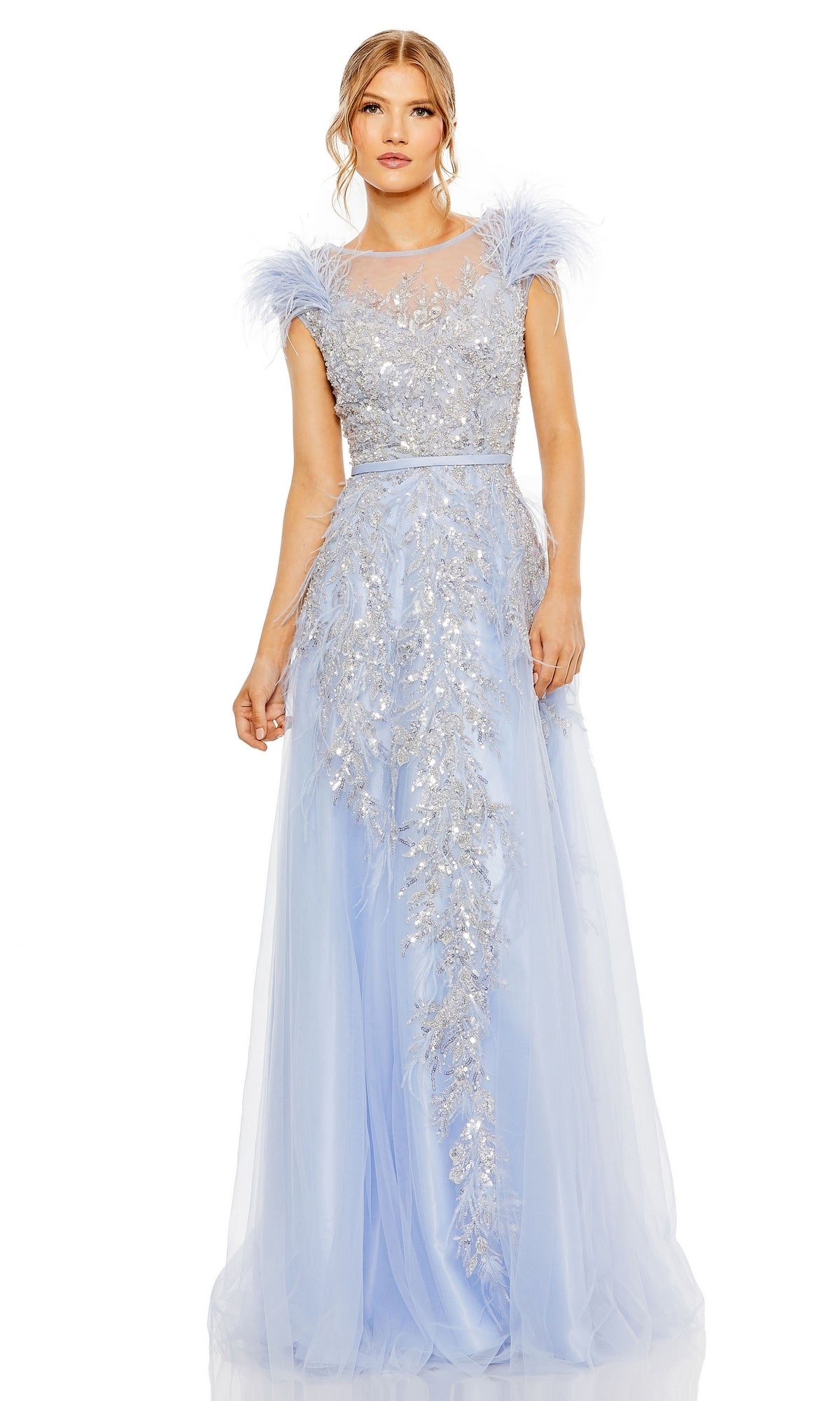 A woman wears the Long Formal Dress 20520 by Mac Duggal—a floor-length, pastel light blue A-line gown with silver floral embellishments, feathered shoulders, and sheer detailing on the bodice and skirt.