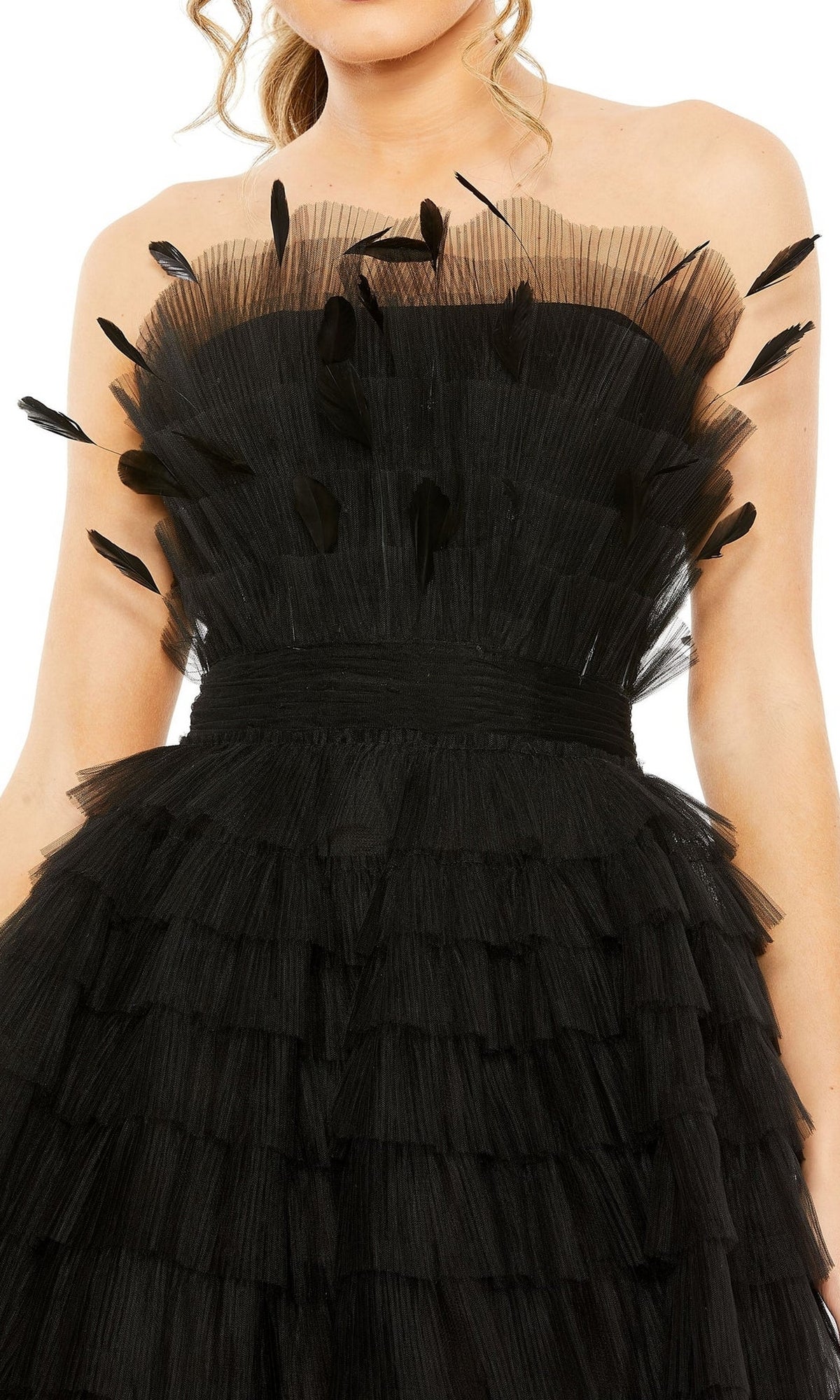 A woman in the Mac Duggal 20529 Strapless Ruffle Party Dress, featuring layered tulle ruffles and black feather accents on the bodice.