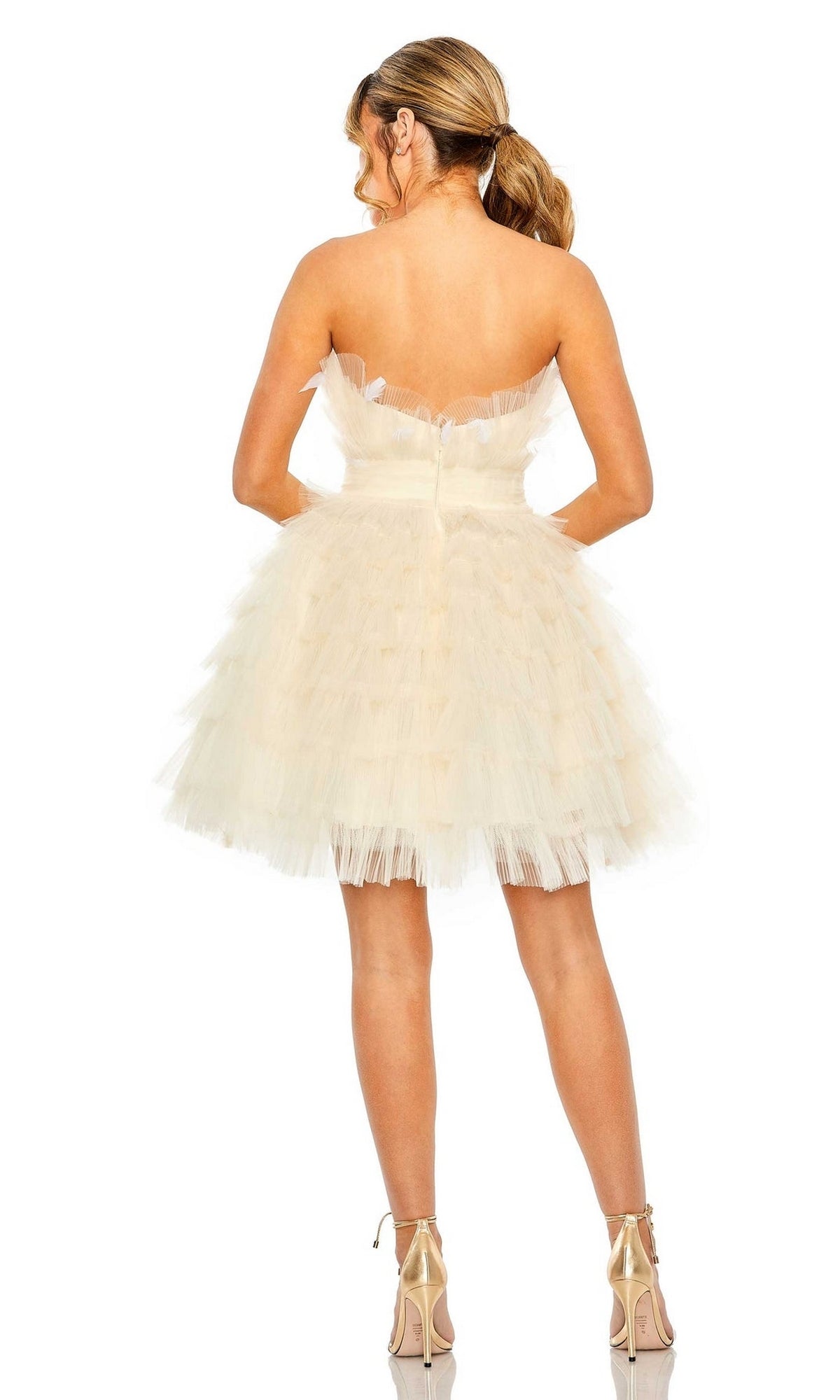 A woman faces away, wearing the Mac Duggal 20529 Strapless Ruffle Party Dress with layered tulle and nude heels, her hair styled in a low ponytail.