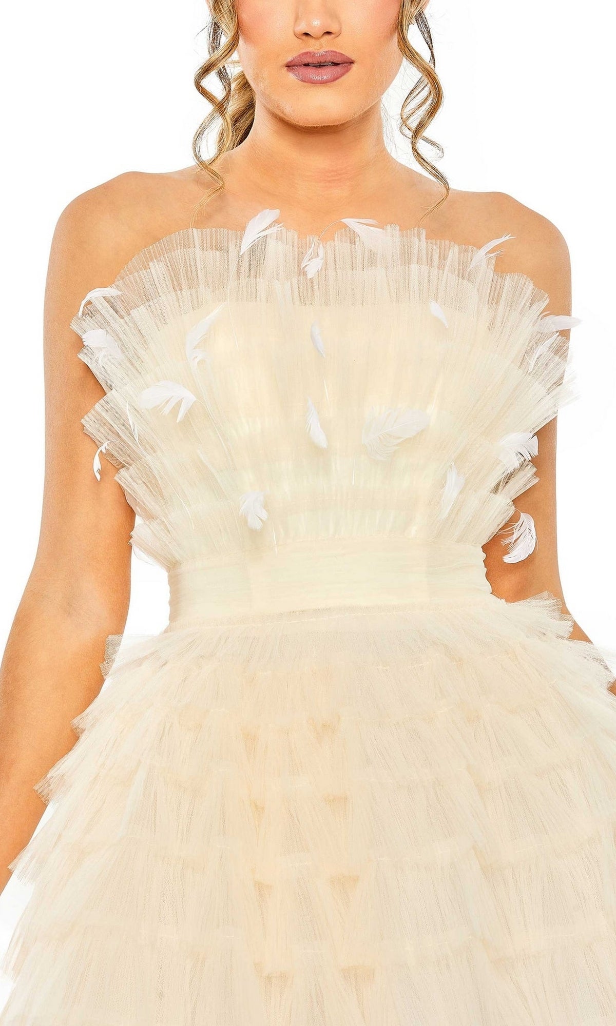 A woman wears the Mac Duggal 20529 Strapless Ruffle Party Dress in cream, featuring ruffled layers and delicate white feather accents.