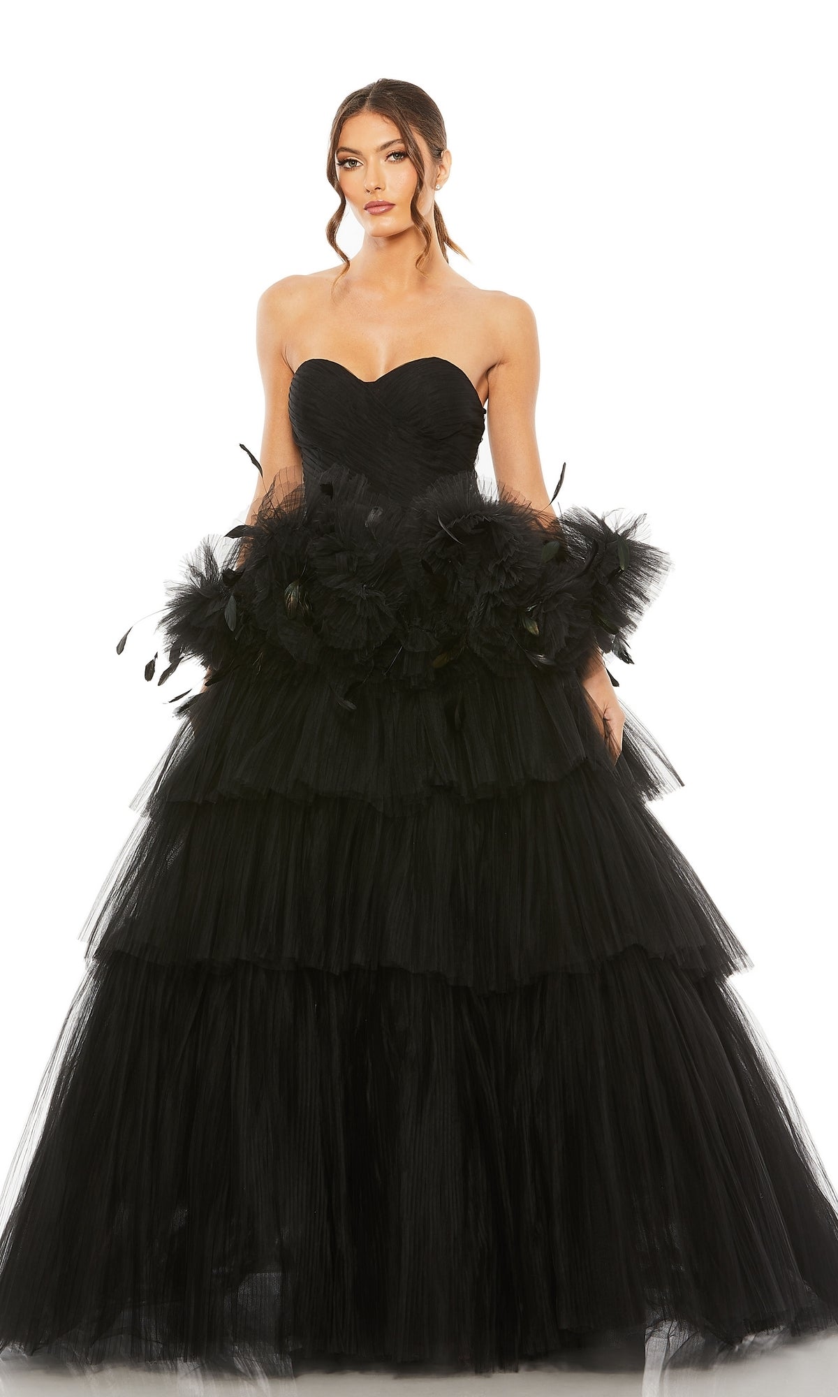 A woman poses in the Long Formal Dress 20572 by Mac Duggal, a strapless ball gown with a sweetheart bodice, tiered tulle layers, and floral waist details, set against a plain white background.