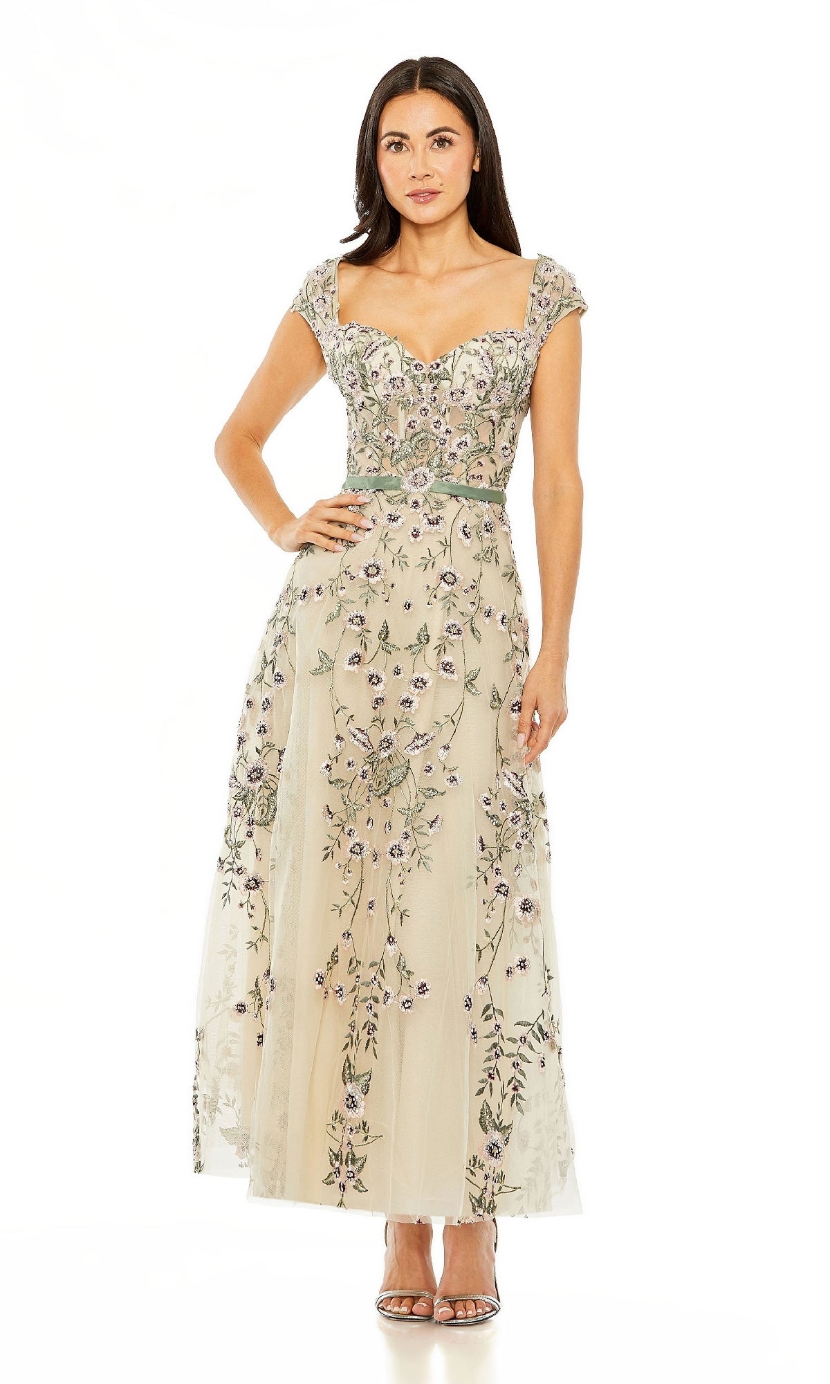 Woman in a Cap-Sleeve Nude Midi Party Dress: Mac Duggal 20582, featuring embroidered floral details, standing against a plain white background with open-toe heels.