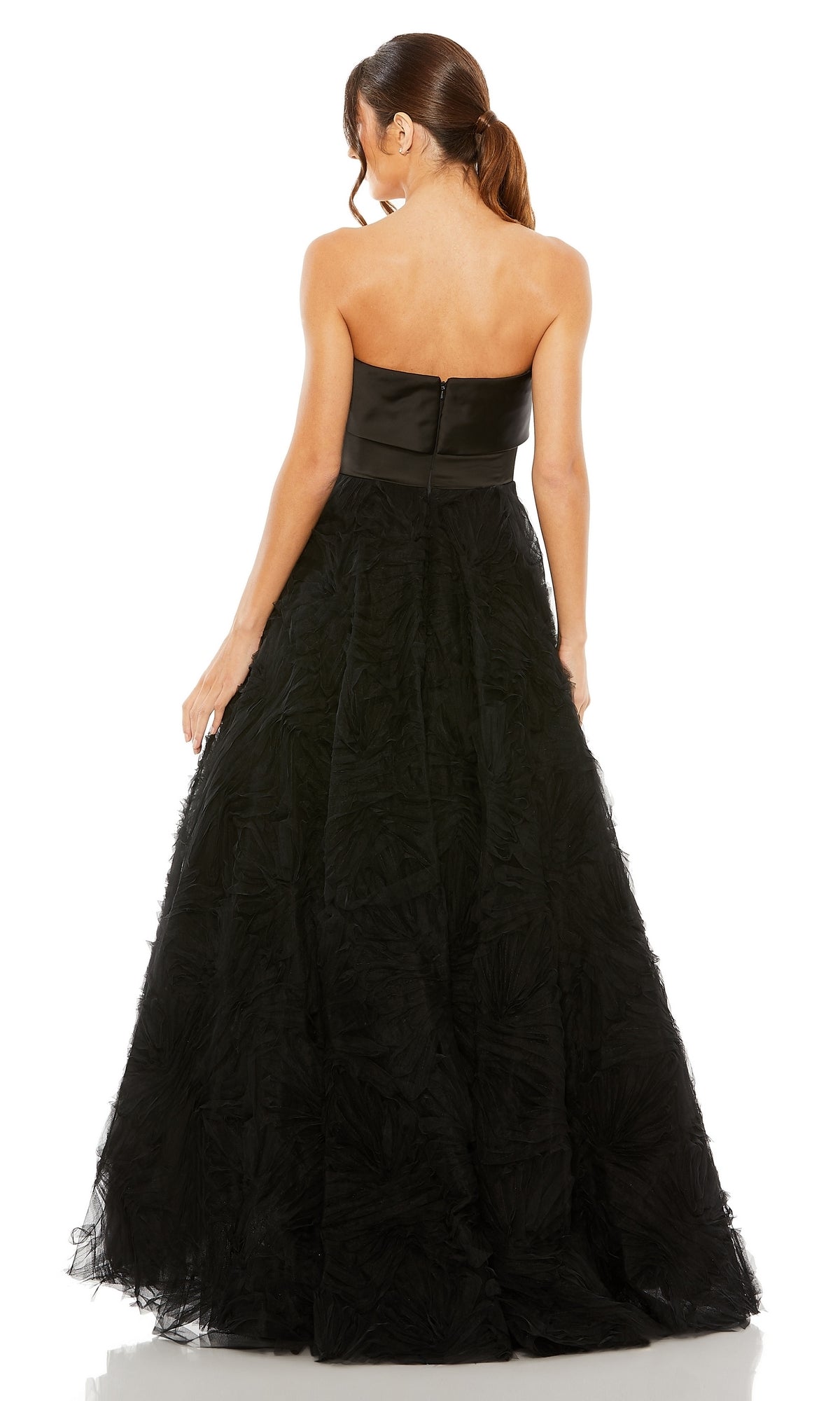 A woman stands with her back to the camera, wearing the Long Formal Dress 20584 by Mac Duggal—a strapless gown with a fitted bodice and a full, textured skirt.