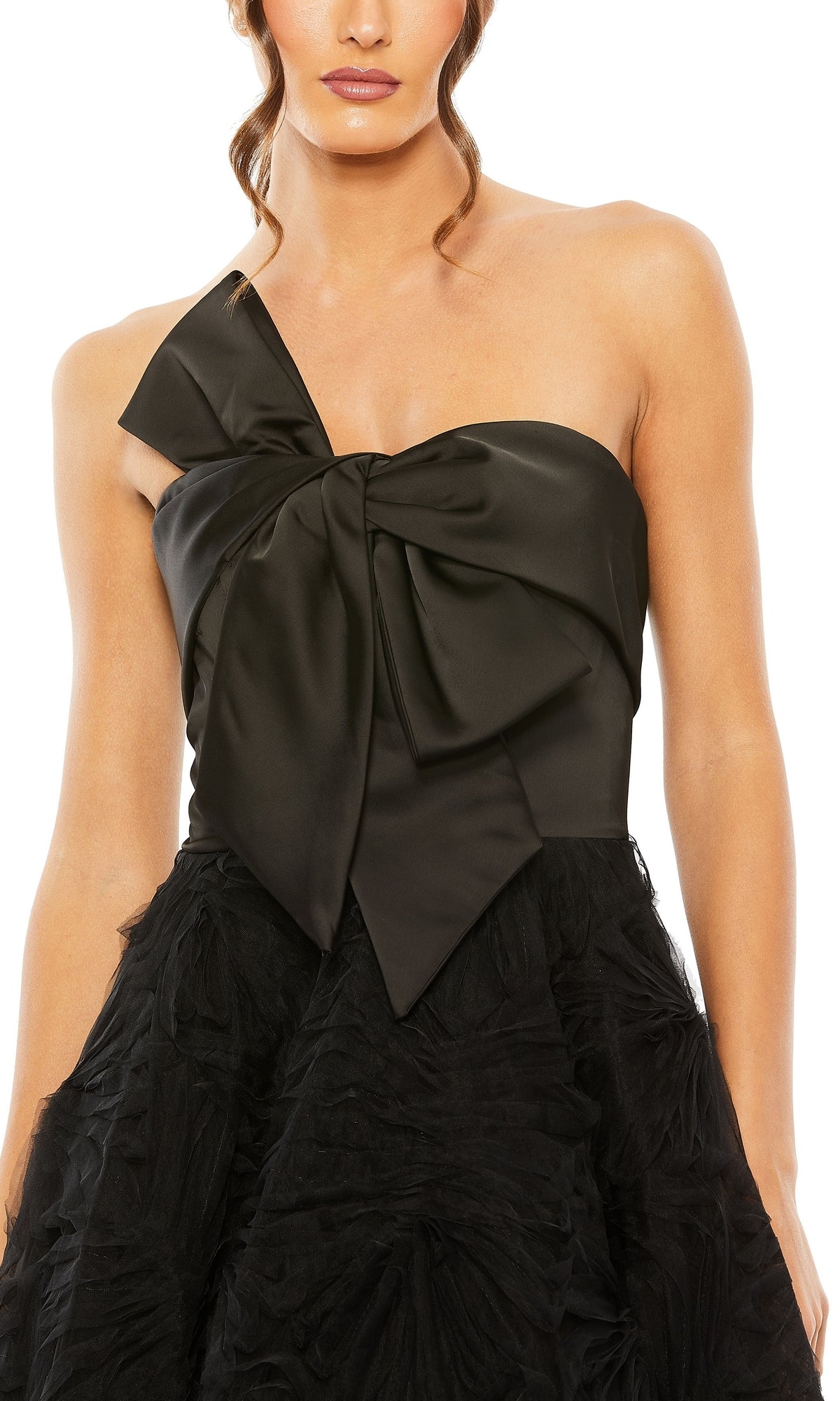 A woman in the Long Formal Dress 20584 by Mac Duggal, a black A-line gown with a one-shoulder design, large satin bow on the bodice, and a textured skirt.