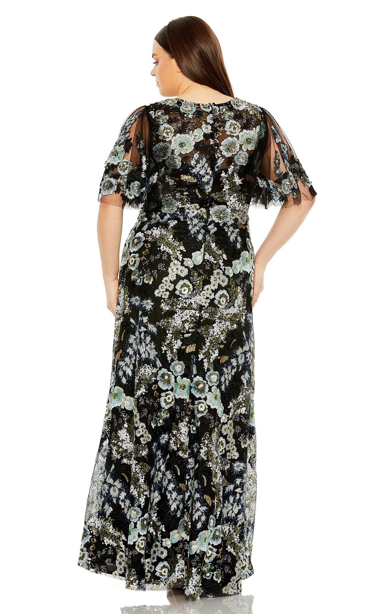 A woman is shown from the back wearing the Long Plus-Size Prom Dress 20630 by Mac Duggal, featuring a black formal design with floral embroidery and sheer short sleeves.