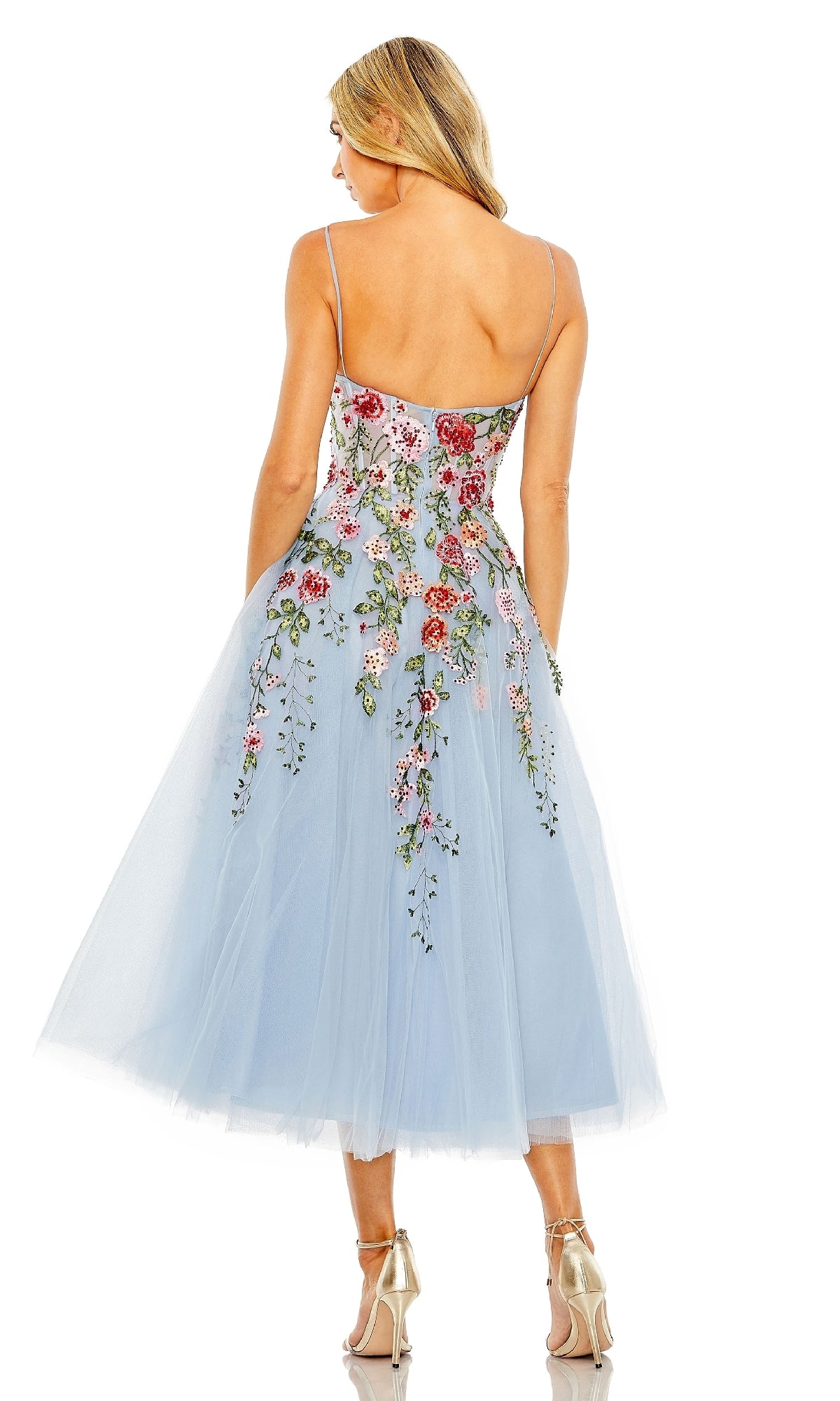 A woman stands with her back to the camera, wearing the Mac Duggal 20651 Floral Embroidered A-Line Midi Dress in light blue, featuring tulle details and strappy heels.