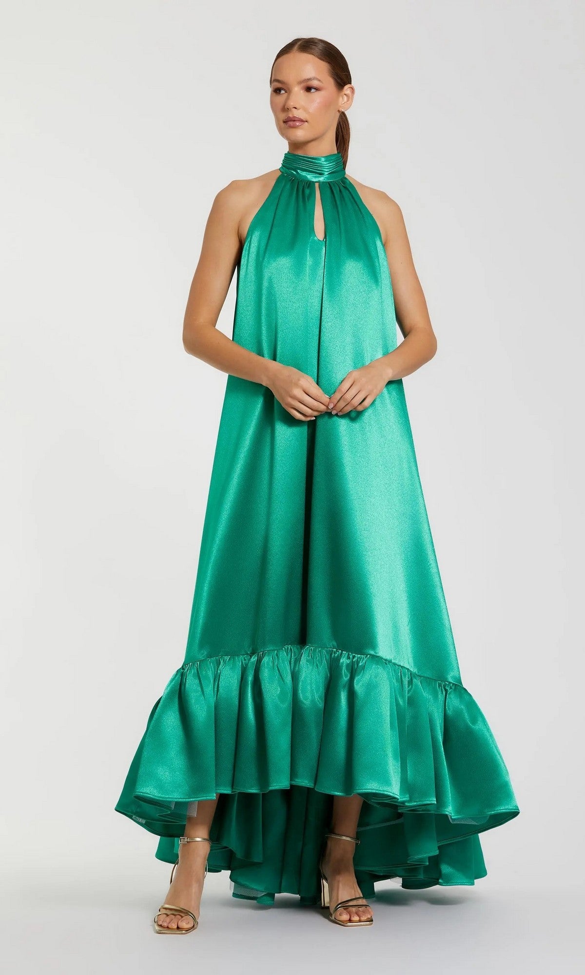 A woman wearing the Mac Duggal 20712 long formal dress in jade—a sleeveless satin halter gown featuring a high-low ruffled hem—stands against a plain background.