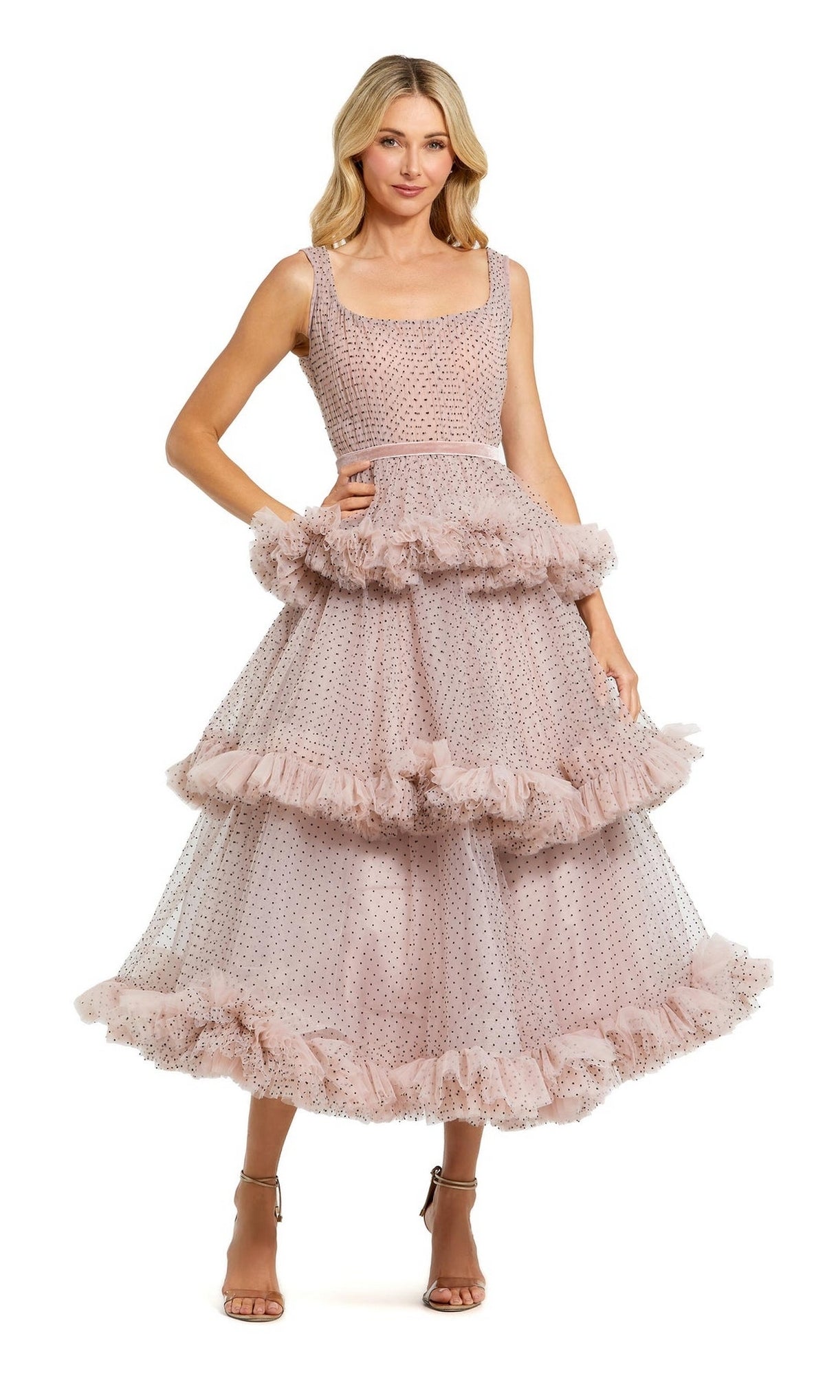 Woman wears the Mac Duggal 20776 Pink Midi Wedding Guest Dress, a sleeveless style with tiered ruffles and polka dots, paired with strappy nude heels for the perfect cocktail look.