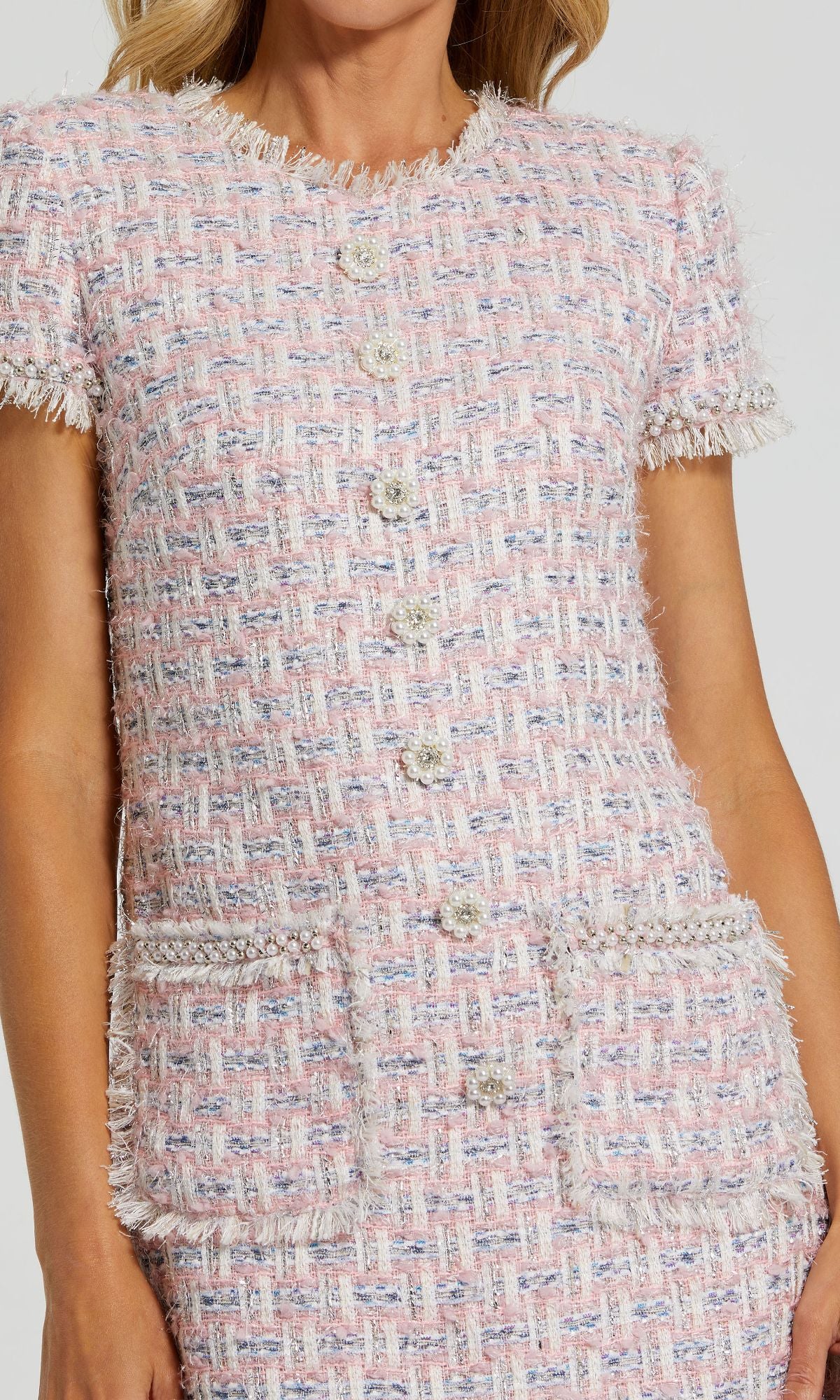 A woman wears the Mac Duggal 20805 short sleeve semi-formal dress, styled with a pastel pink and white tweed jacket featuring front buttons and two large pockets for a chic, party-ready look.