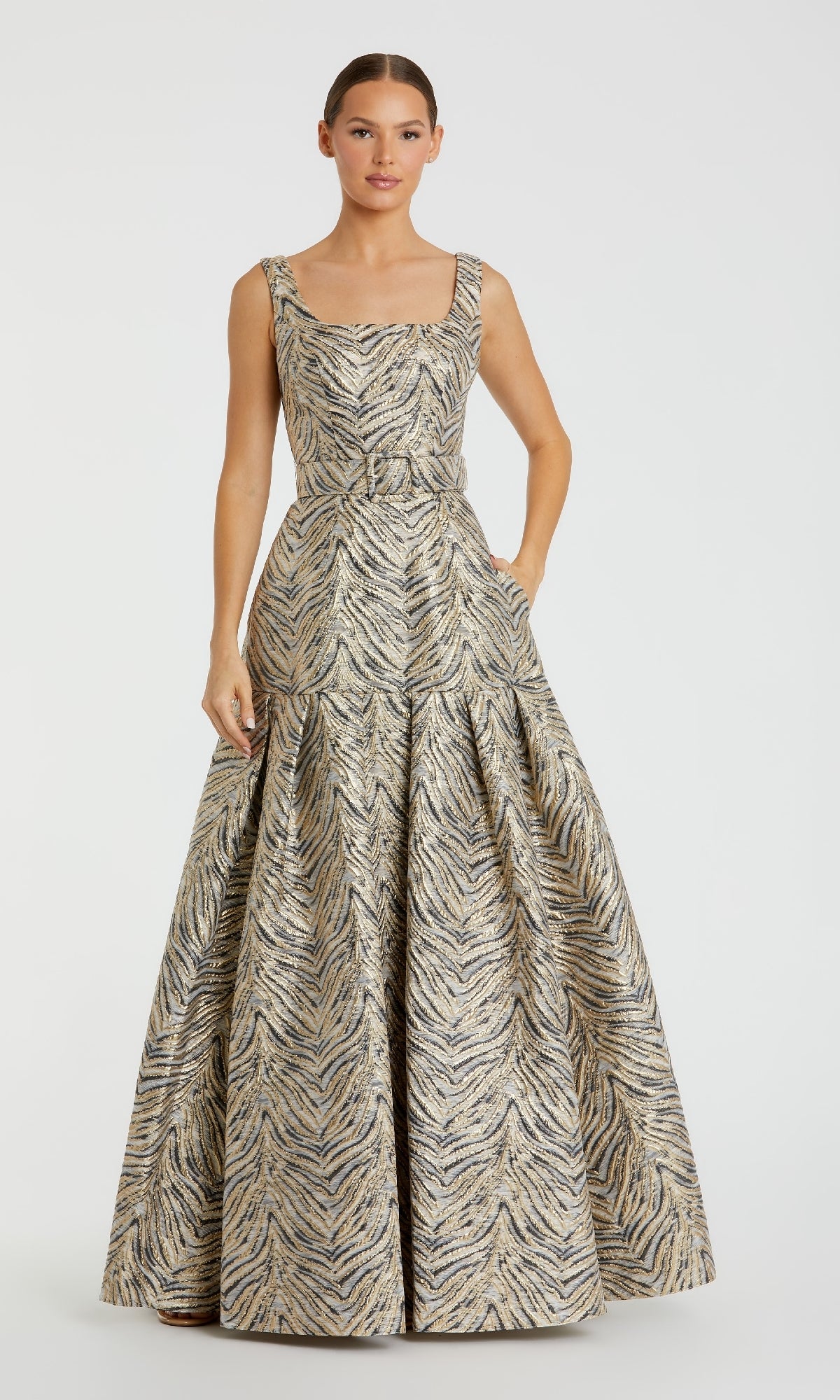A woman wears the Mac Duggal 21054 Gold Zebra-Print Long Prom Gown—a sleeveless, floor-length dress with a fitted bodice and flared skirt.