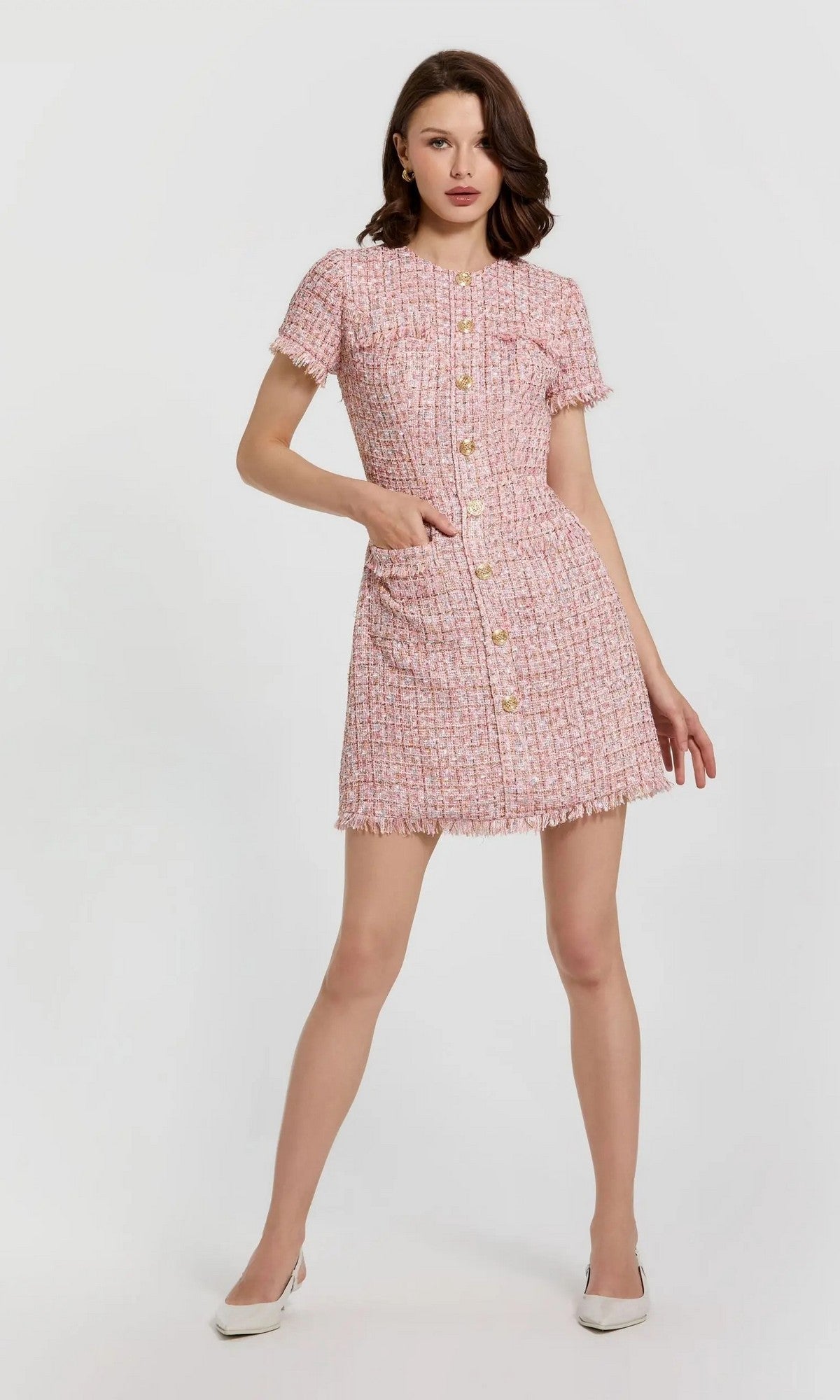 A woman wearing the Short Wedding Guest Dress: Mac Duggal 21072, a pink boucle mini sheath with front buttons, pockets, and high neckline, poses against a plain light background.