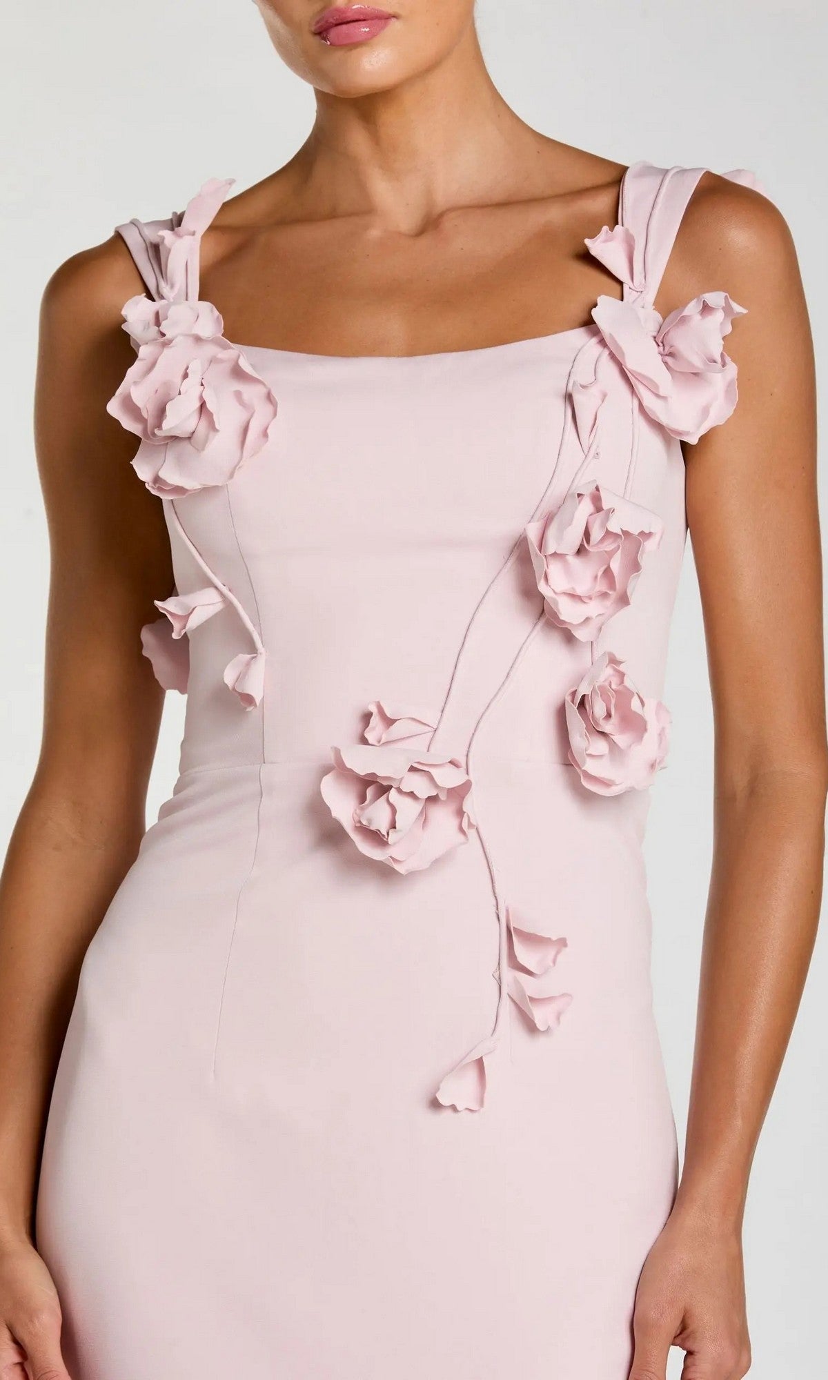 A woman wearing the Mac Duggal 21236 long formal dress in pale pink, featuring three-dimensional fabric flower appliqués on the straps and bodice.
