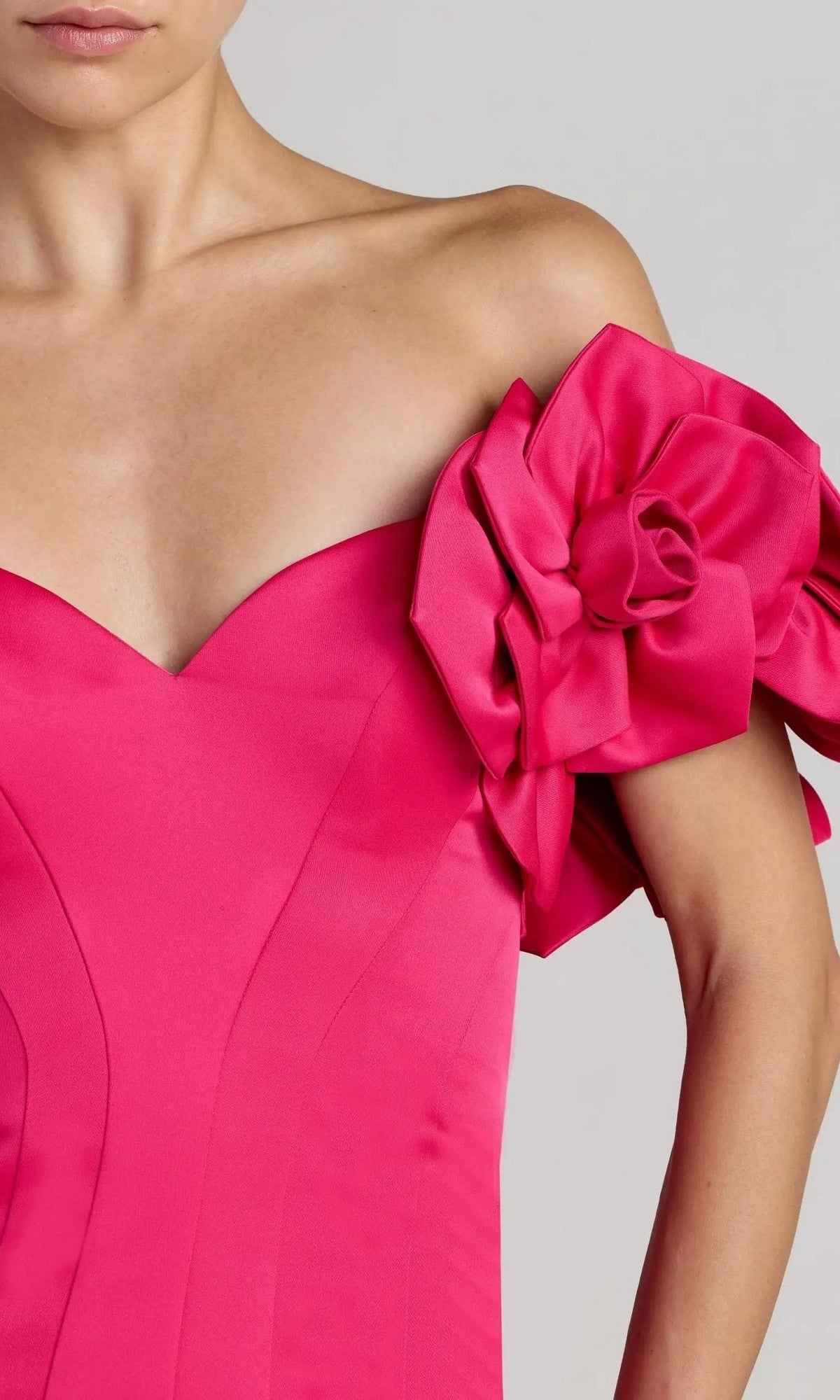 A woman wearing the Mac Duggal 21263 Long Formal Dress in hot-pink satin, showcasing an off-the-shoulder silhouette with a dramatic, sculpted floral sleeve detail—an exquisite choice for any elegant occasion.
