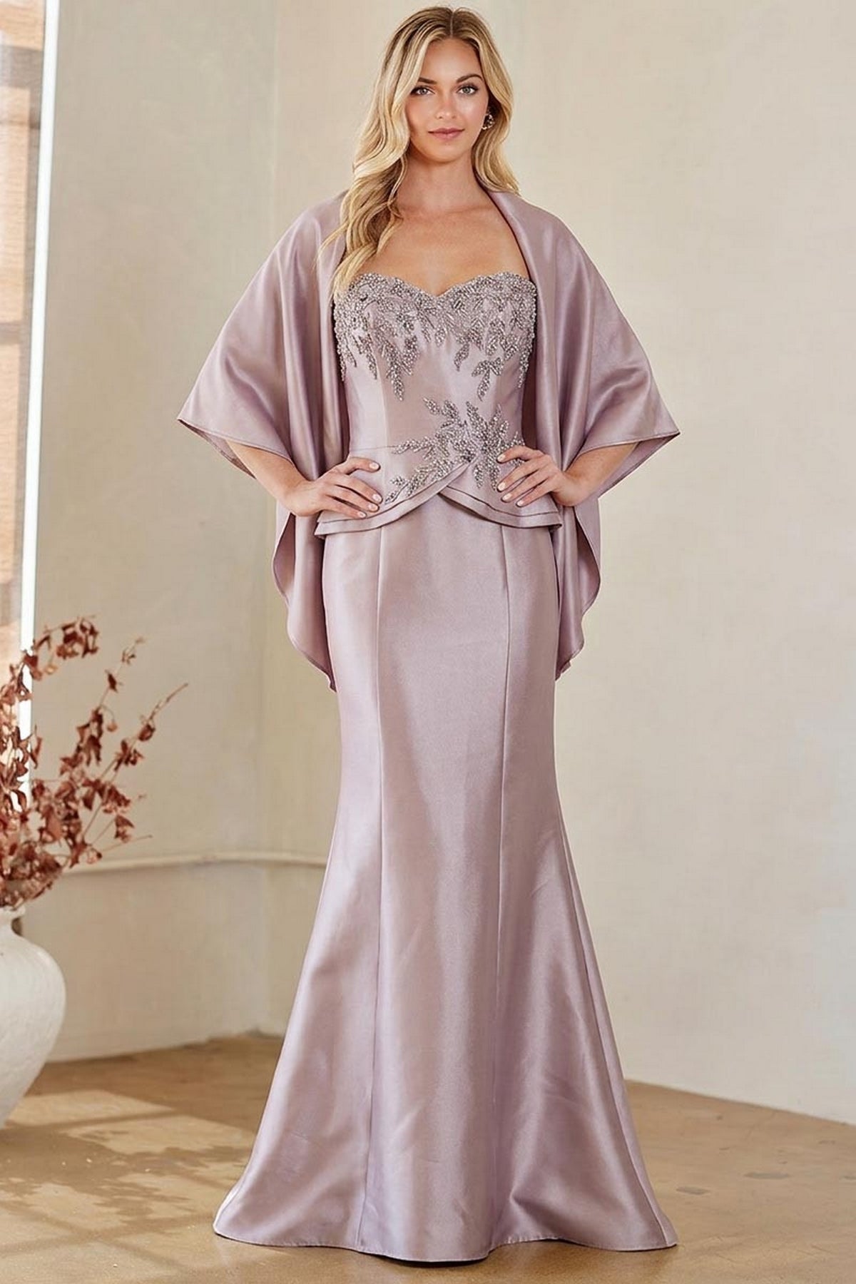 The Amelia Couture 2162 is a floor-length mauve beaded evening gown featuring a sweetheart neckline and a matching cape-style shawl.