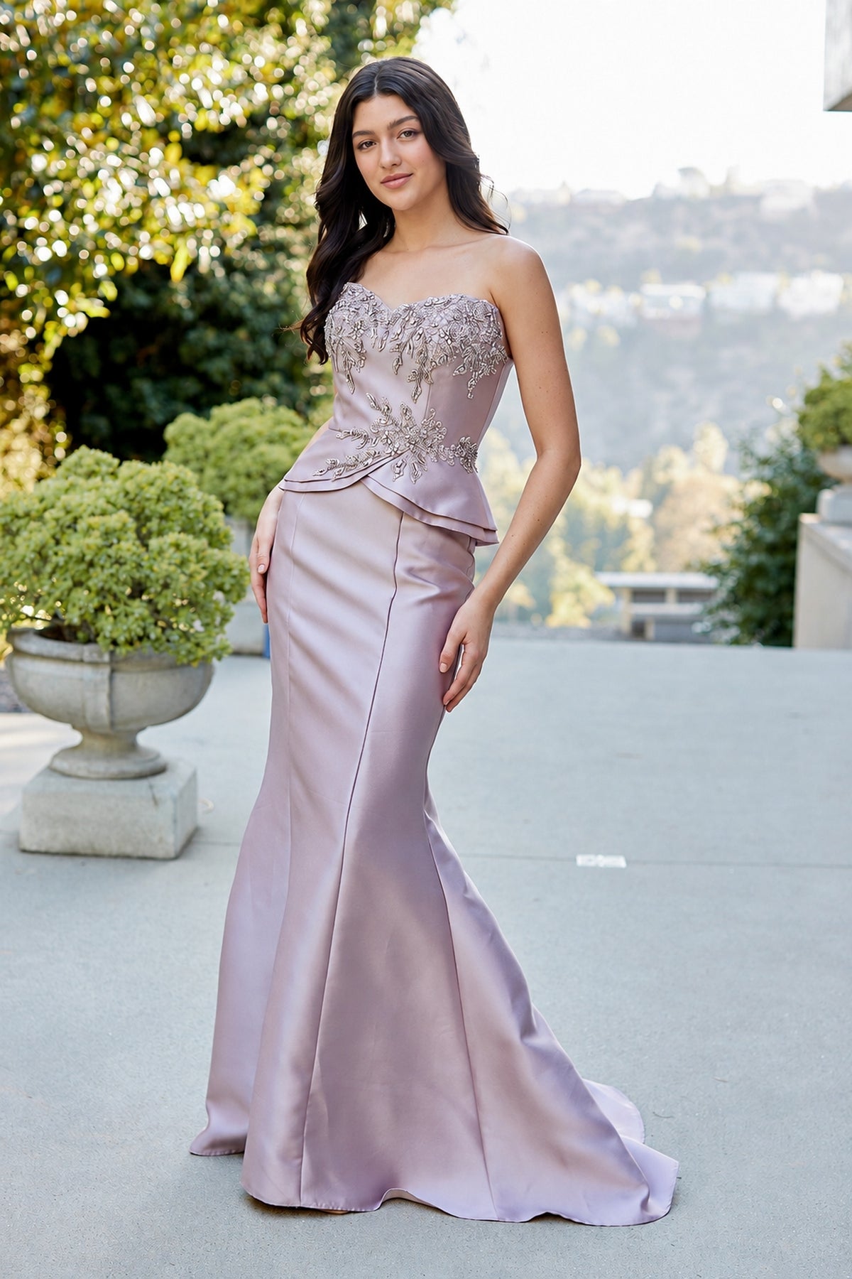 The Amelia Couture 2162 is a strapless dark mauve formal gown featuring an embellished bodice and a peplum waist.