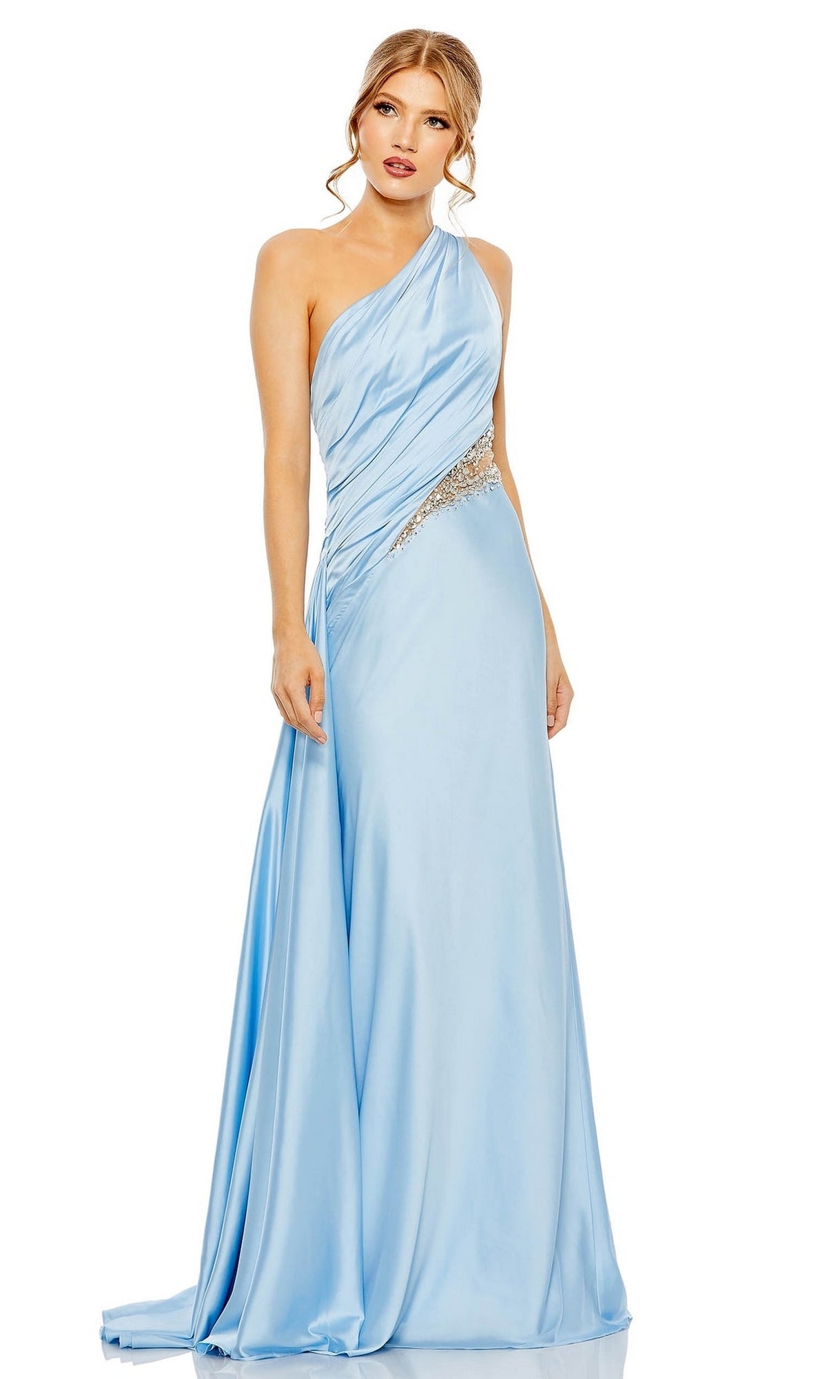 A woman wears the Mac Duggal 2210 Cut-Out One-Shoulder Formal Dress in light blue, featuring a jeweled waistband, standing against a plain white background.