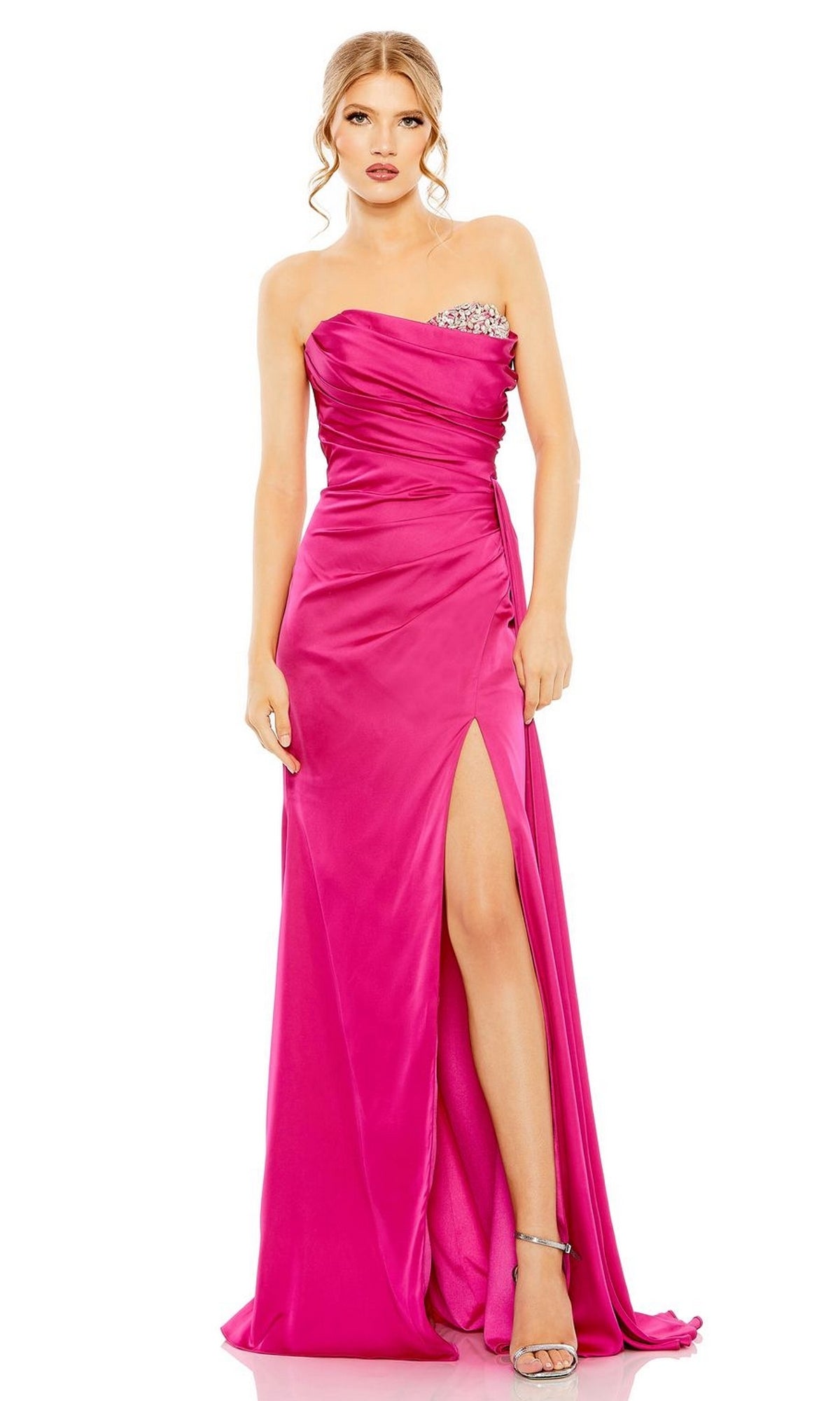 A woman in a pink Mac Duggal 2211 Side-Drape Strapless Prom Gown with a pleated bodice, elegantly styled.
