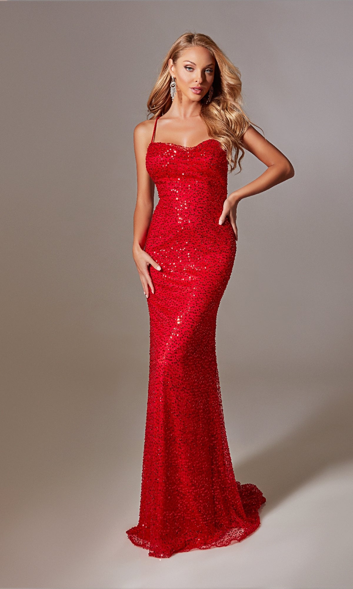 A woman models the Strappy Long Sequin Prom Dress: Aerie Couture 222—a fitted, floor-length red gown with thin straps—standing against a neutral background.